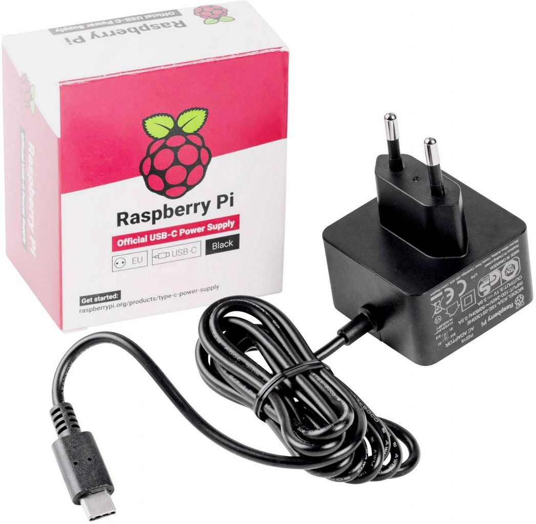 Raspberry Pi Netzteil-Set: Box, schwarzer Adapter und Kabel. Box hat Logo und Text. Adapter hat Stifte.