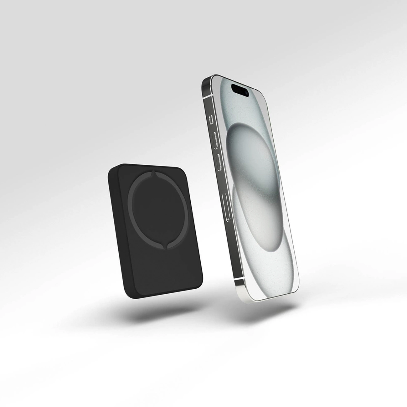Eine schwarze Powerbank und ein silbernes iPhone schweben vor weißem Hintergrund. Das Telefon zeigt ein verschwommenes Bild.
