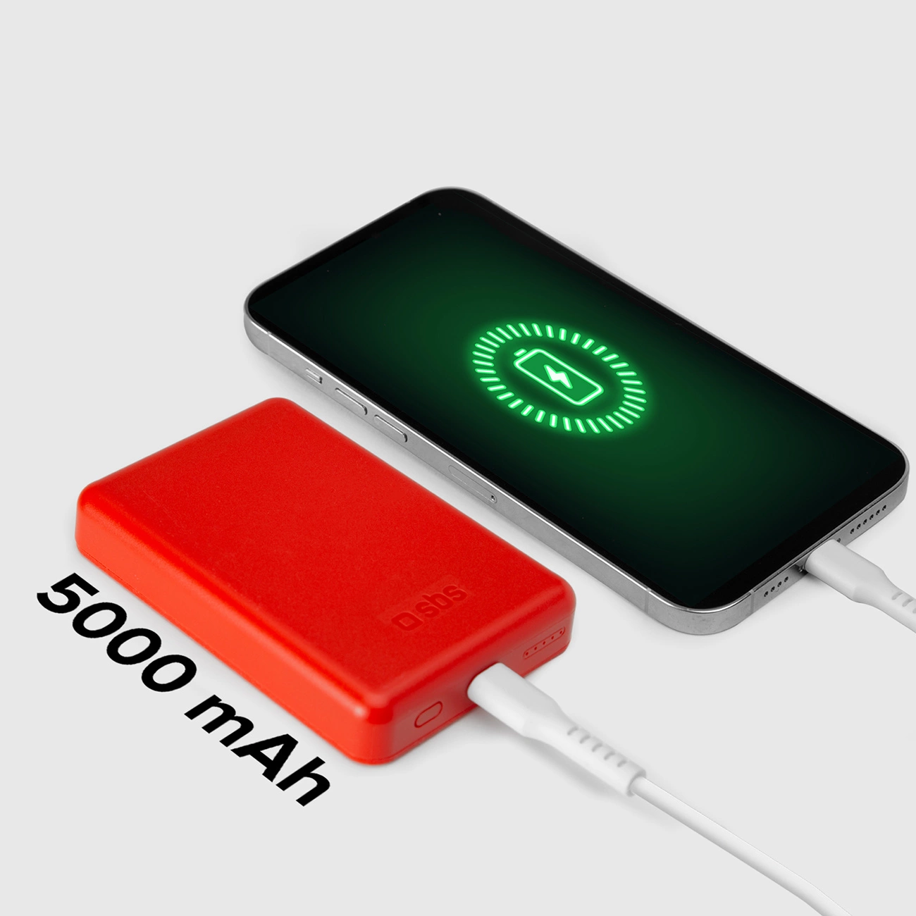 Czerwony power bank z napisem 5000 mAh ładuje telefon. Na ekranie telefonu widoczna ikona ładowania.