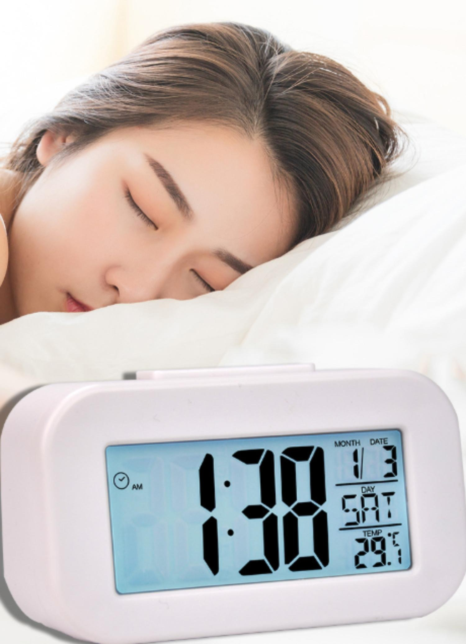 Eine Frau schläft neben einer weißen Uhr. Die Uhr zeigt 1:38 Uhr morgens, Datum 1/3, Samstag und 29,1°C Temperatur an.
