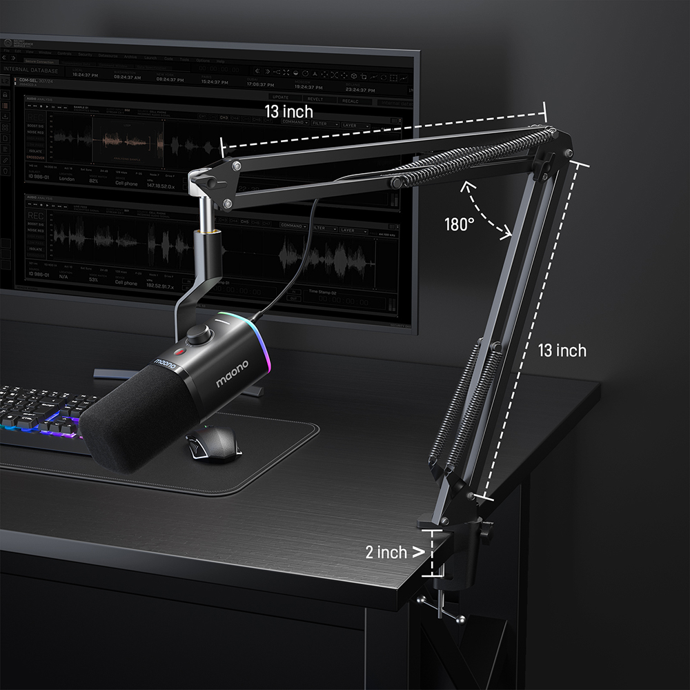 Ein Mikrofon mit Pop-Filter ist auf einem schwarzen Schreibtisch mit einem verstellbaren Arm montiert. Ein Monitor und eine Tastatur sind im Hintergrund.