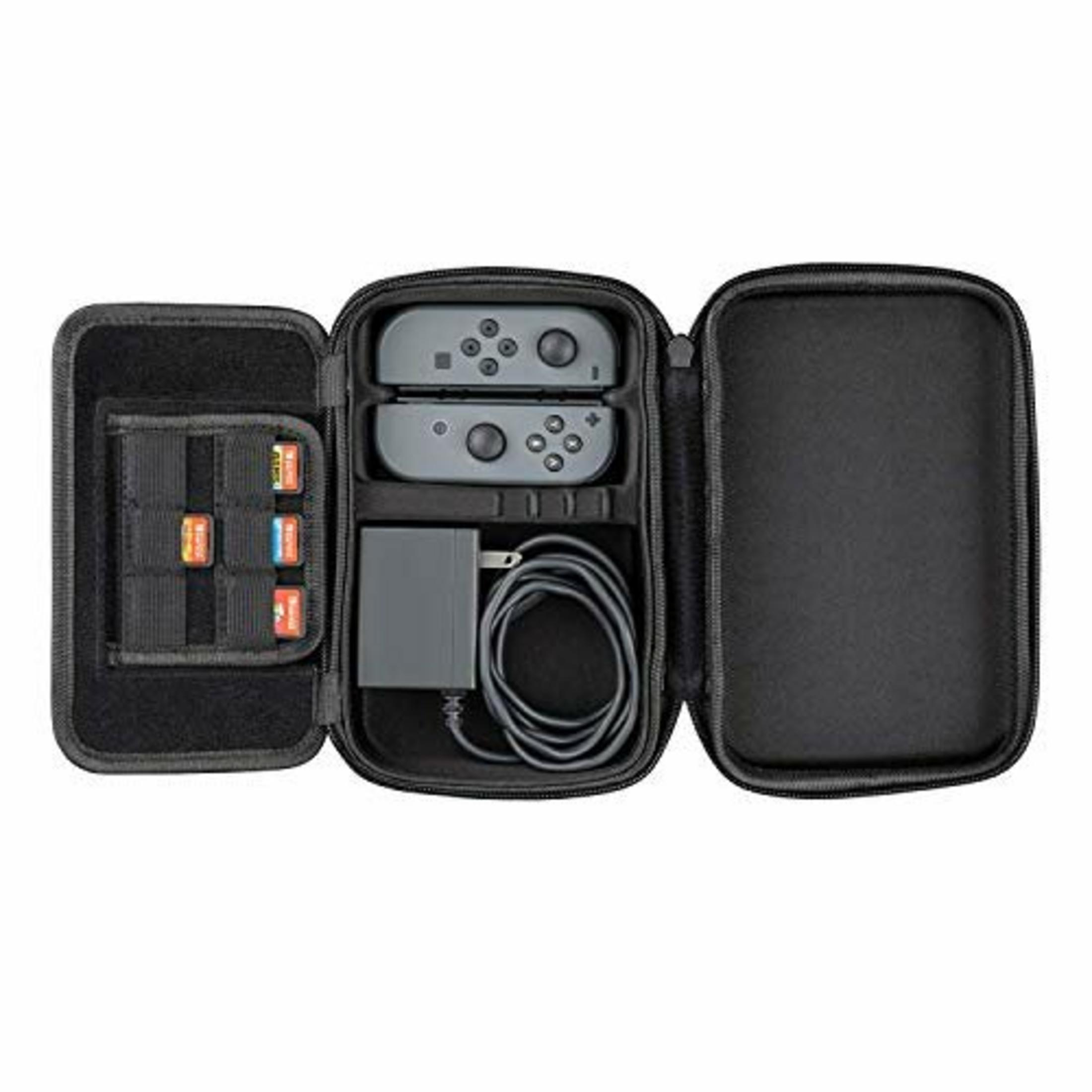 Otwarta czarna walizka z kablem ładującym, dwoma szarymi kontrolerami i kartridżami do gier.