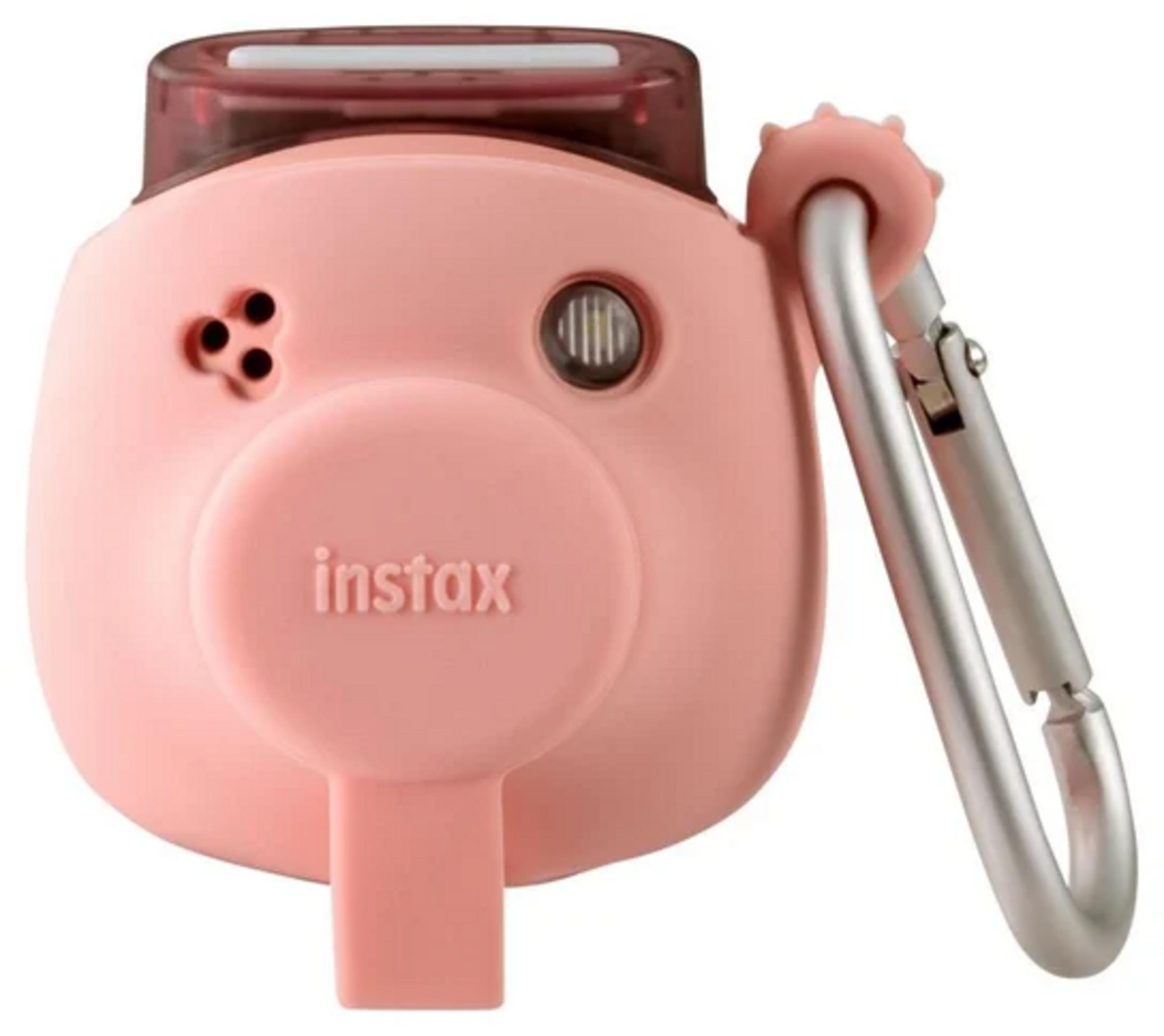 Różowy aparat Instax ze srebrnym klipsem. Aparat ma obiektyw, lampę błyskową i markę 'instax'.