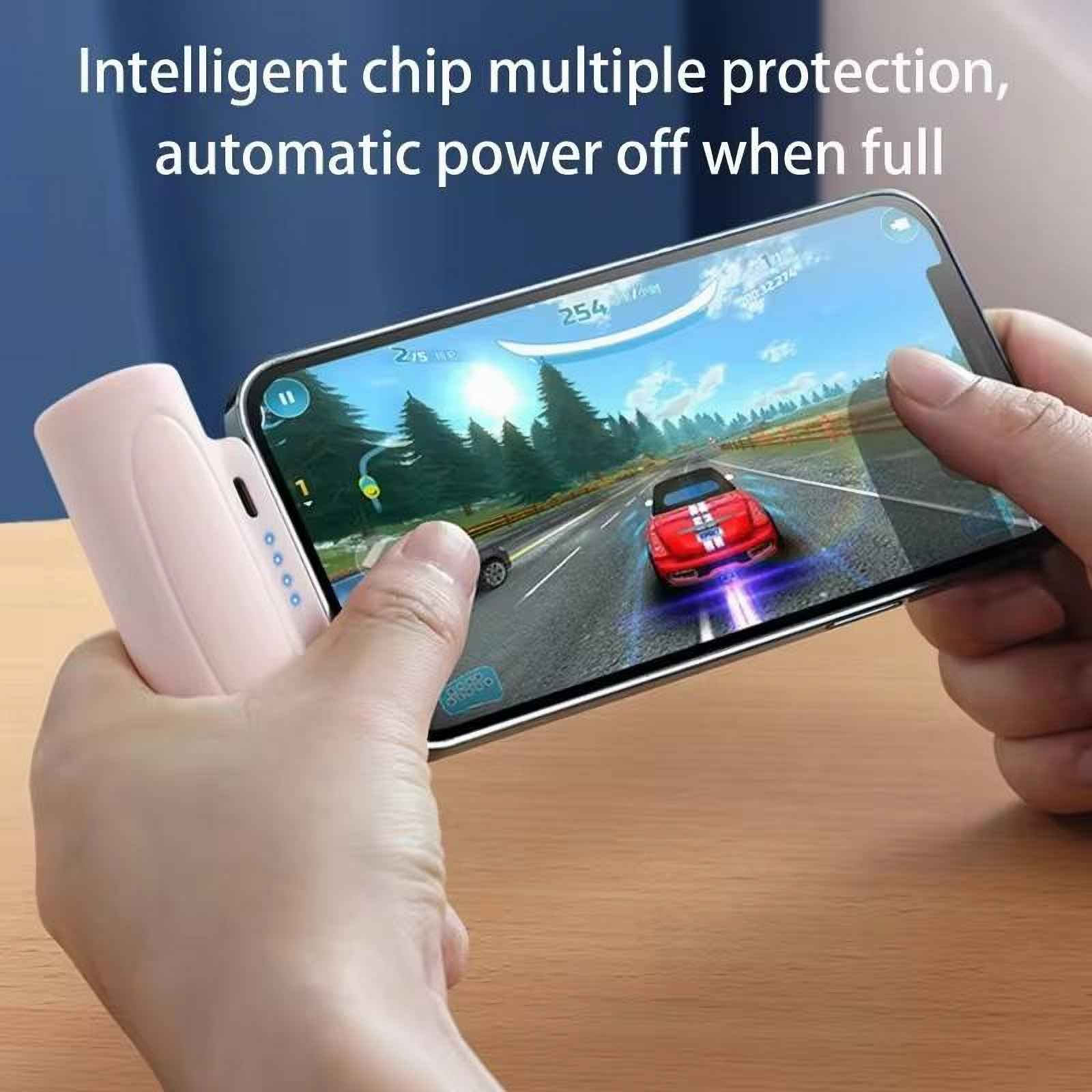 Eine Person spielt ein Rennspiel auf einem Telefon, das mit einer Powerbank verbunden ist. Das Auto ist rot.