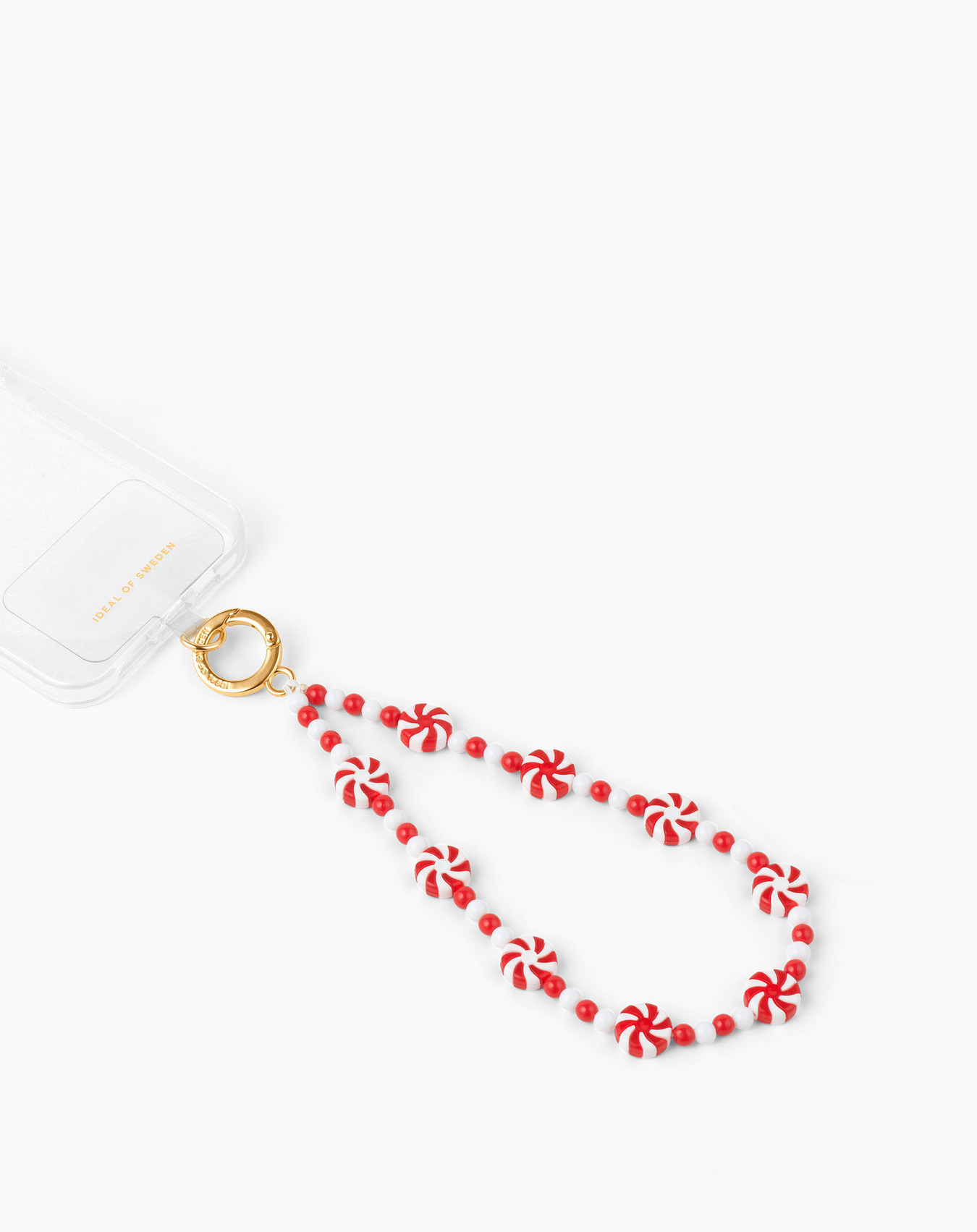 Eine Handyhülle mit einem Zuckerstangenriemen. Der Riemen ist rot und weiß, mit einem goldenen Verschluss. Weißer Hintergrund.