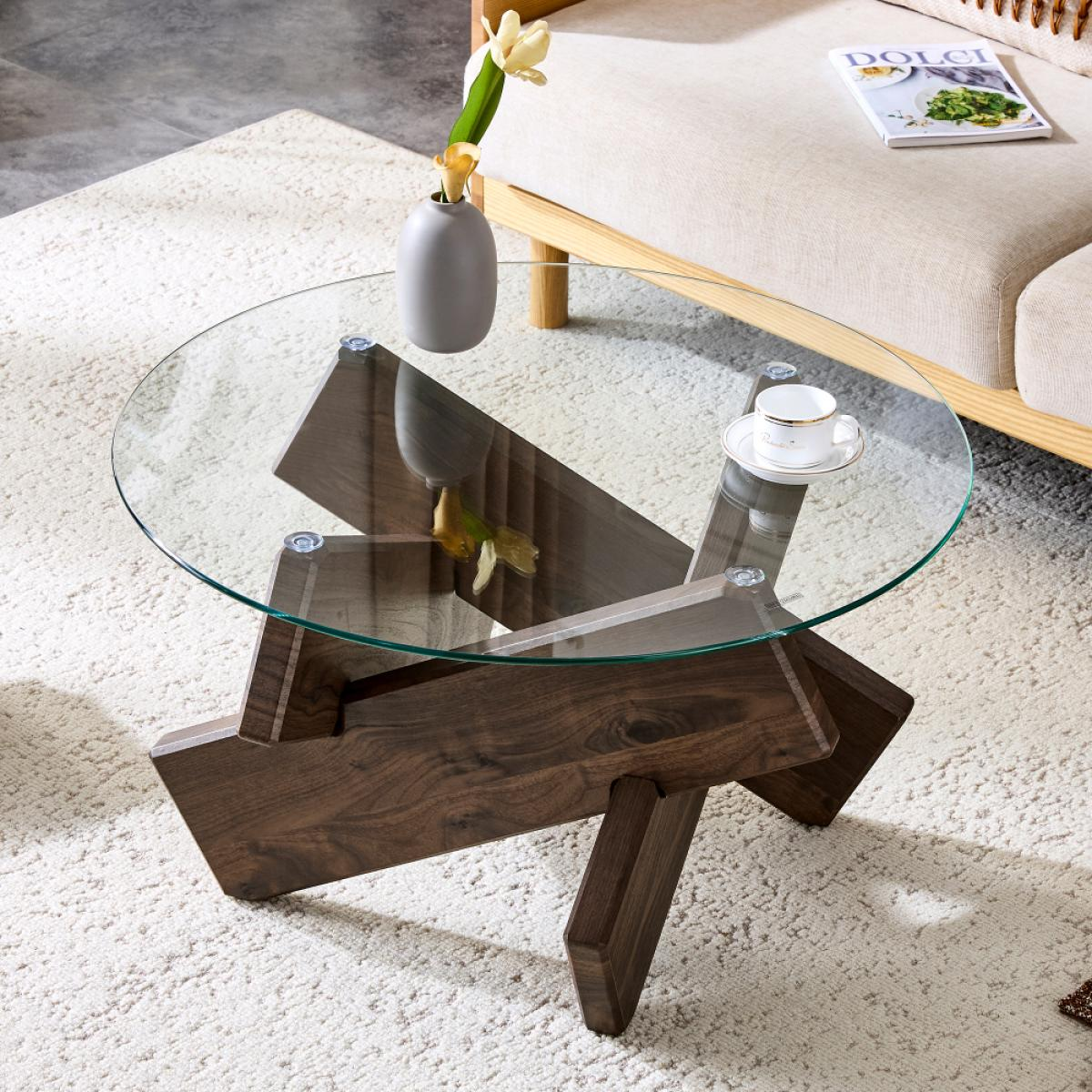 Ein moderner Couchtisch mit Glasplatte. Eine Vase mit Blumen und eine Teetasse stehen auf dem Tisch. Im Hintergrund sind ein Sofa und eine Zeitschrift zu sehen.