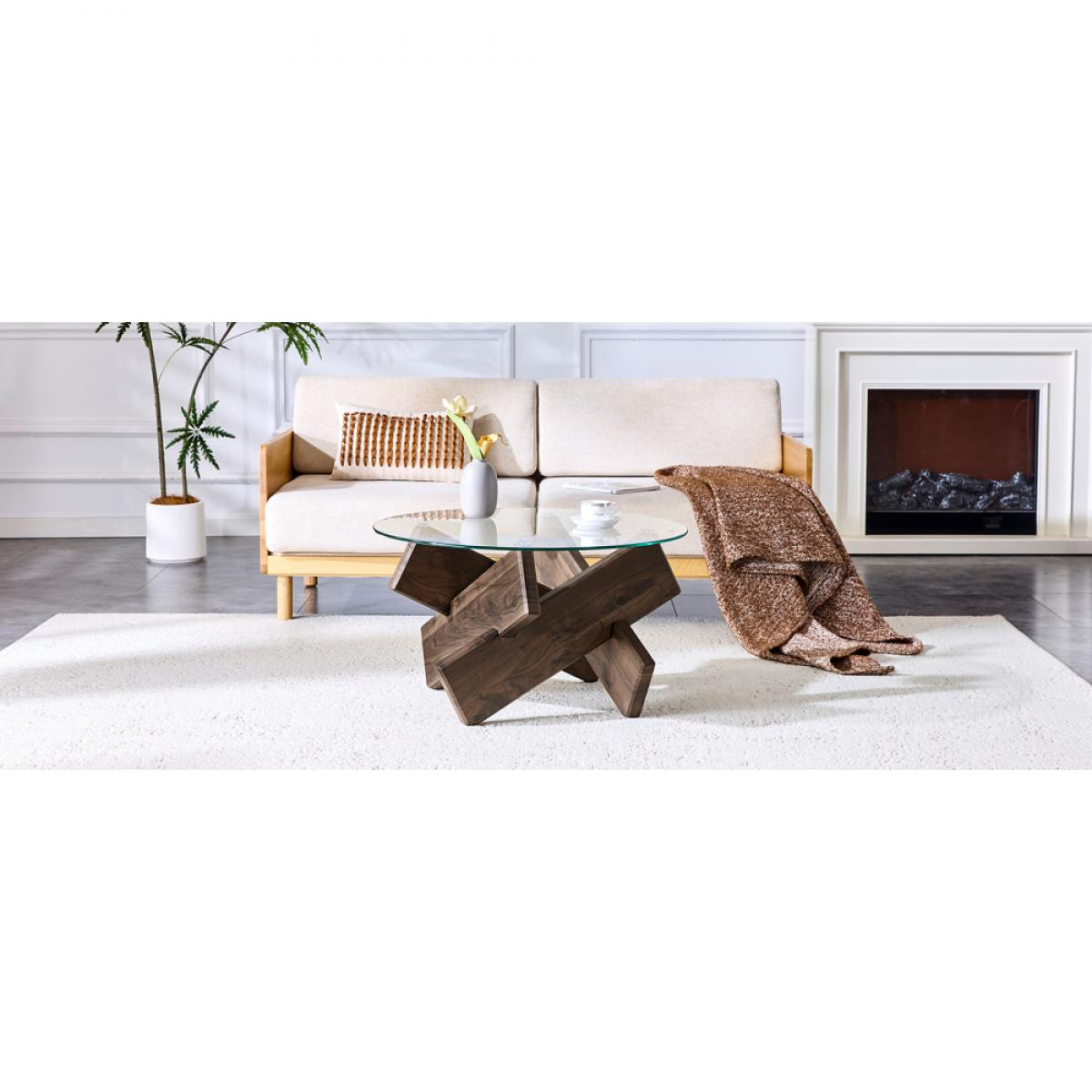 Modernes Wohnzimmer mit Holztisch, Sofa, Kamin und weißem Teppich. Eine Decke liegt über dem Sofa.