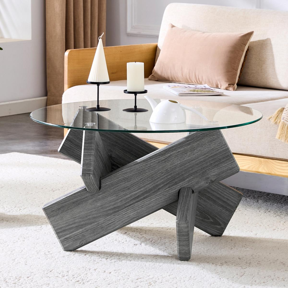Ein modernes Wohnzimmer mit grauem Holztisch, Glasplatte und Kerzen. Im Hintergrund steht ein beiges Sofa.