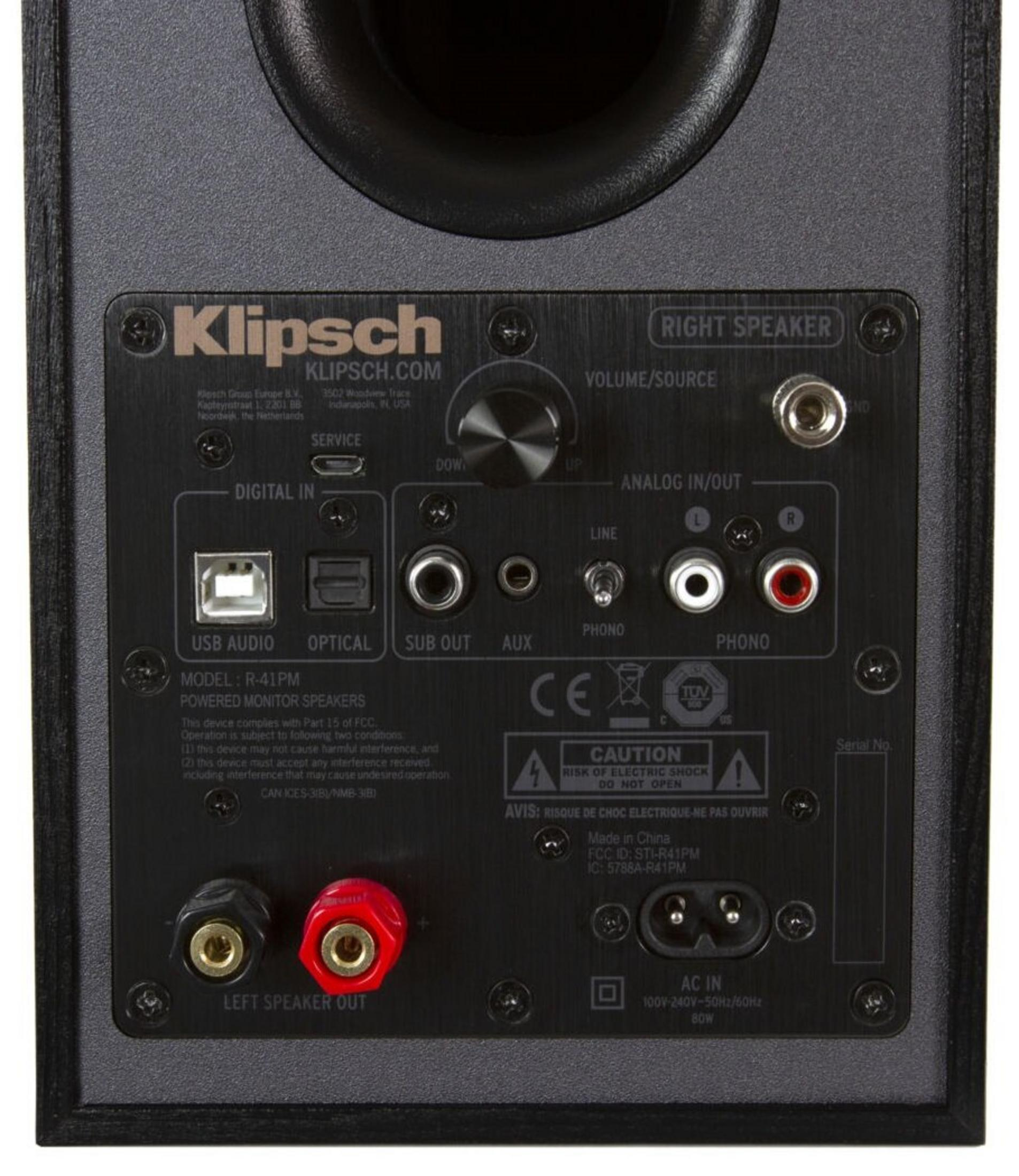 Panneau arrière d'un haut-parleur Klipsch, noir avec connecteurs, étiquettes et logos. Comprend entrées/sorties, alimentation et connexions.