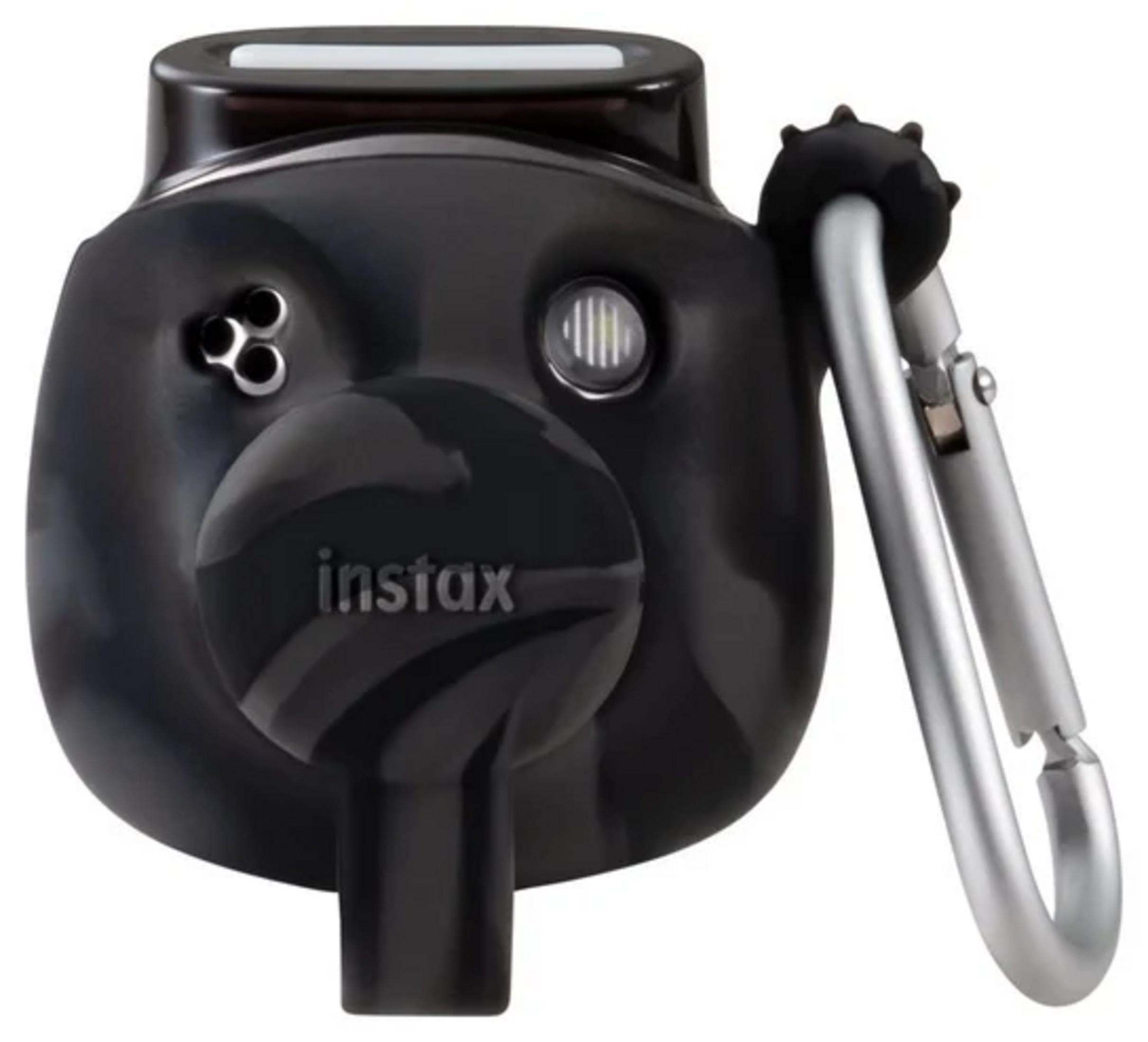 Schwarze Instax-Kamera mit silbernem Clip. Sie hat ein Objektiv und einen Blitz. Die Kamera befindet sich auf weißem Hintergrund.