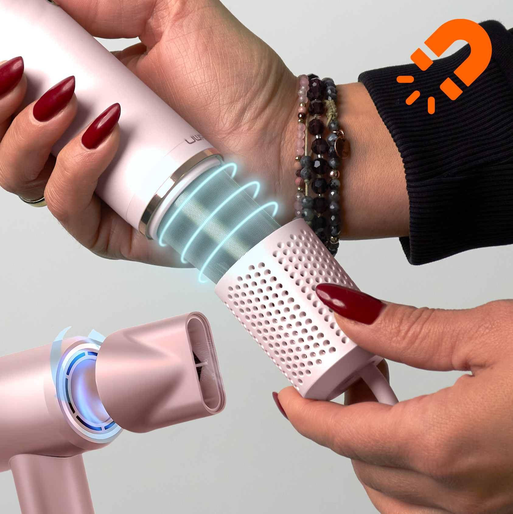Ręce montują różową suszarkę do włosów. Filtr jest odłączony. Czerwony lakier do paznokci. Biżuteria na nadgarstku. Pomarańczowa ikona magnesu.