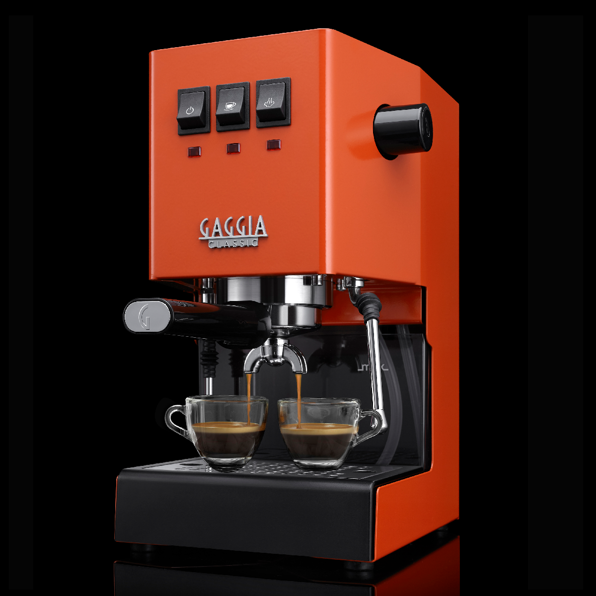 Een oranje Gaggia Classic espressomachine. Twee kopjes vullen zich met koffie. Zwarte achtergrond.