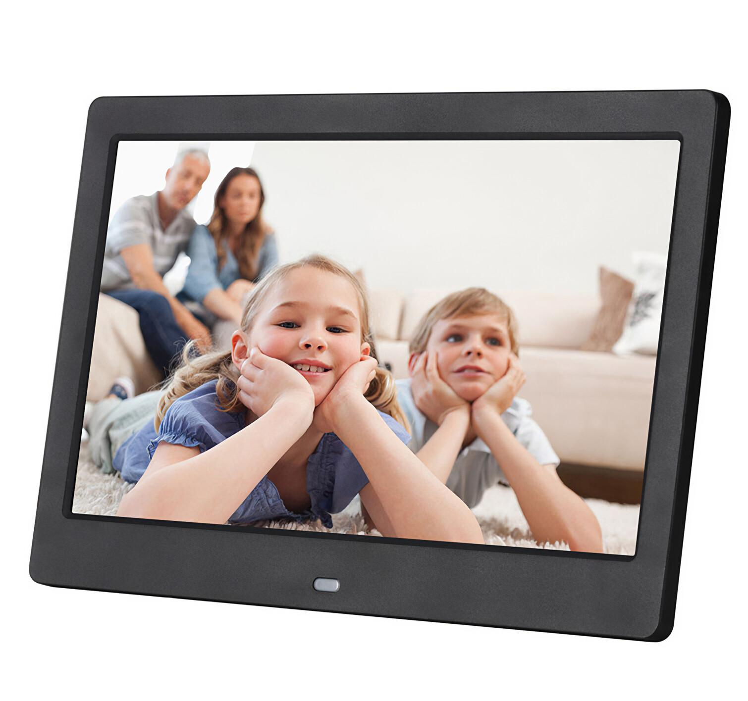 Ein digitaler Bilderrahmen zeigt ein Familienfoto. Zwei Kinder auf dem Teppich schauen den Betrachter an, die Eltern sitzen im Hintergrund auf einem Sofa.