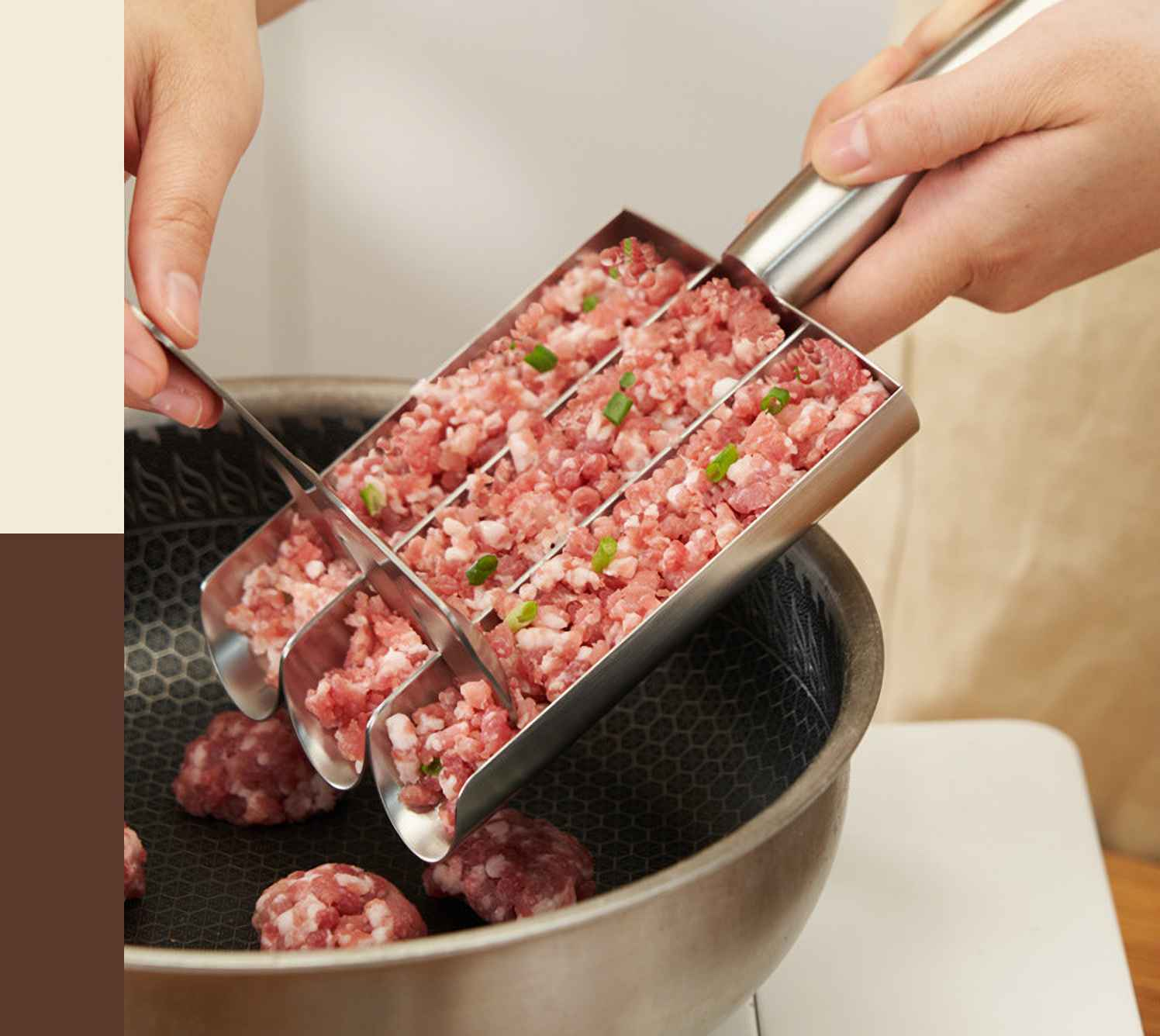 Eine Person verwendet ein Edelstahlwerkzeug, um gehacktes Fleisch mit Frühlingszwiebeln in eine Pfanne zu geben. Es bilden sich Fleischbällchen.