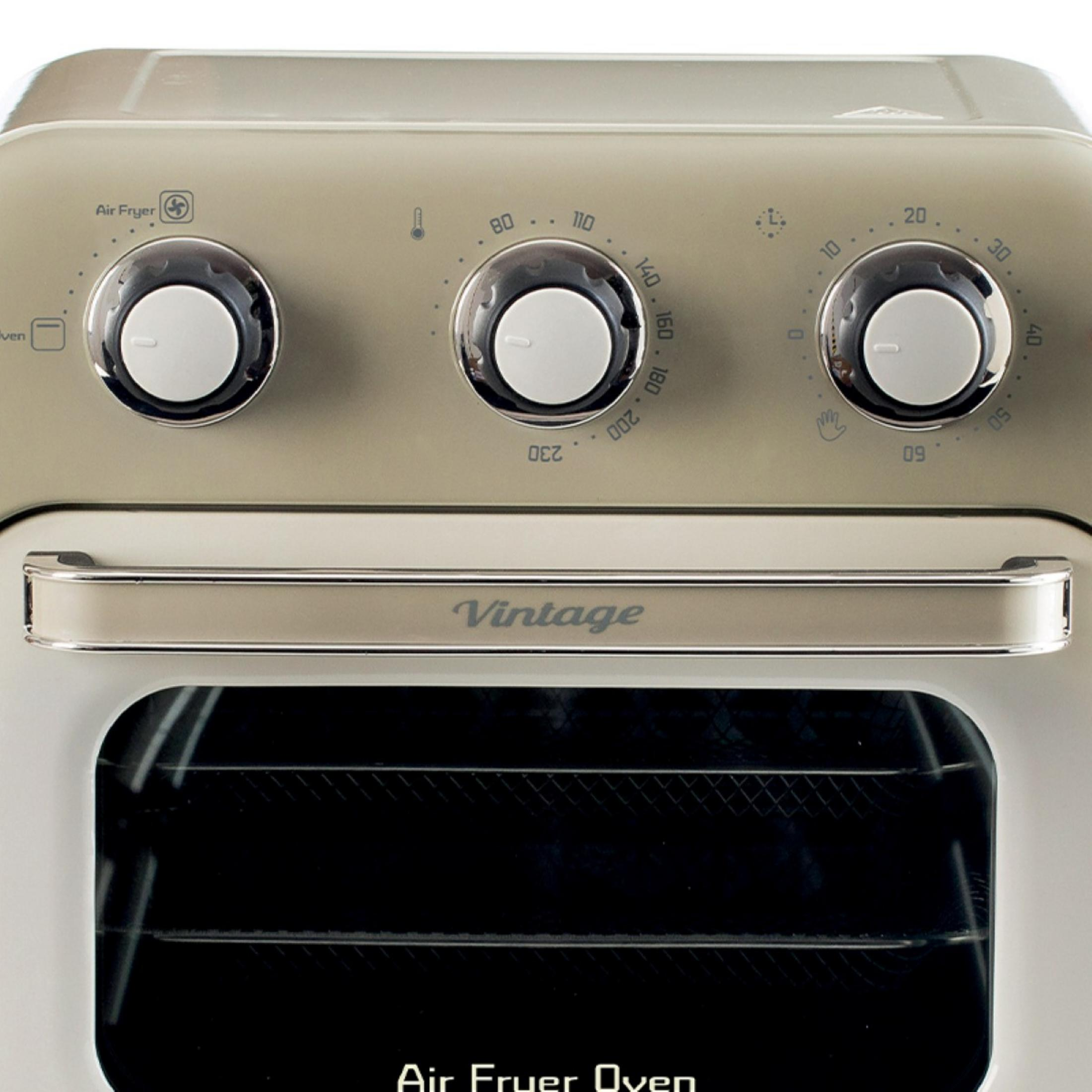 Zbliżenie na piekarnik z frytkownicą powietrzną w stylu vintage z pokrętłami i uchwytem. Drzwi piekarnika są zamknięte.