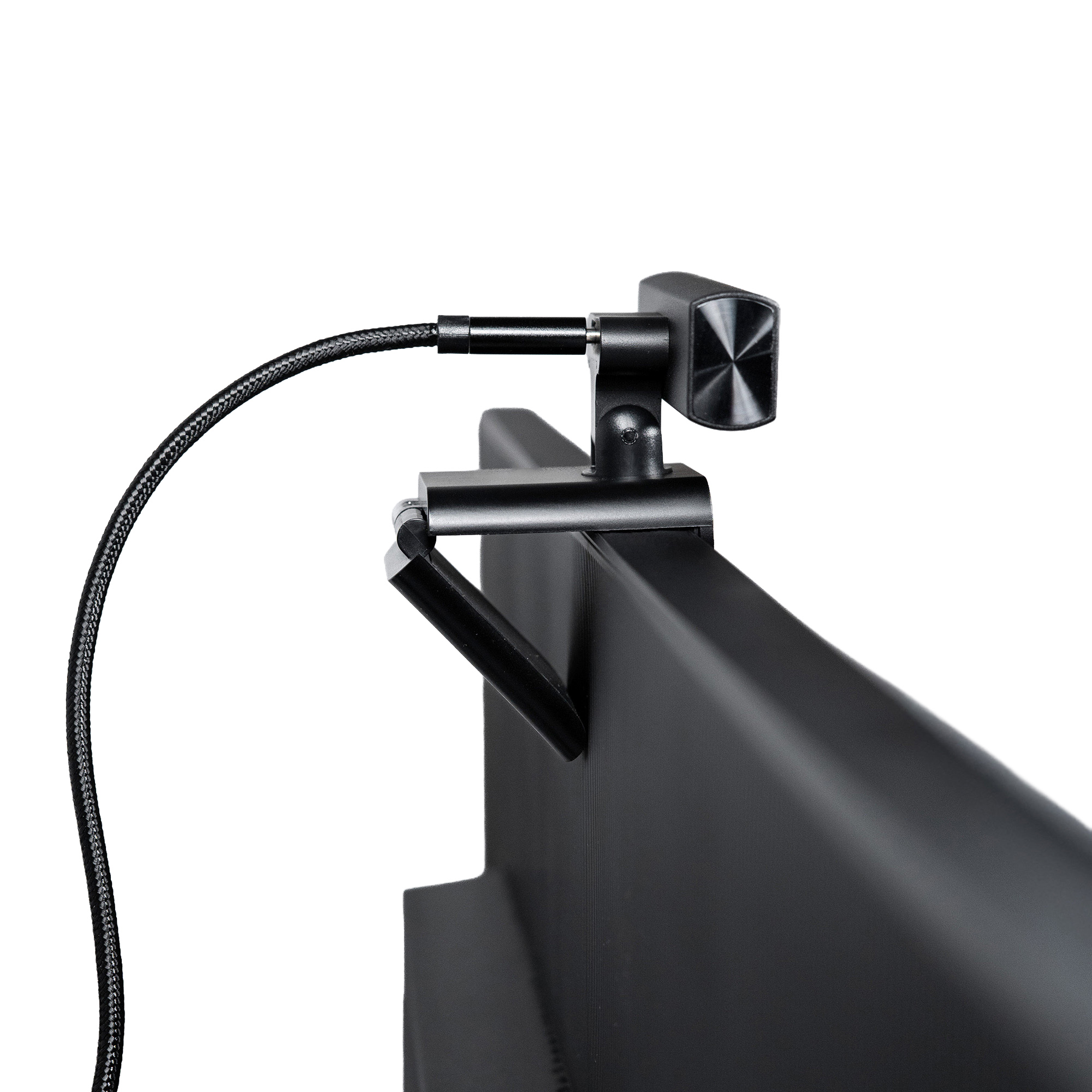 Eine schwarze Webcam, die an einem schwarzen Monitor befestigt ist. Die Webcam hat ein geflochtenes Kabel. Weißer Hintergrund.