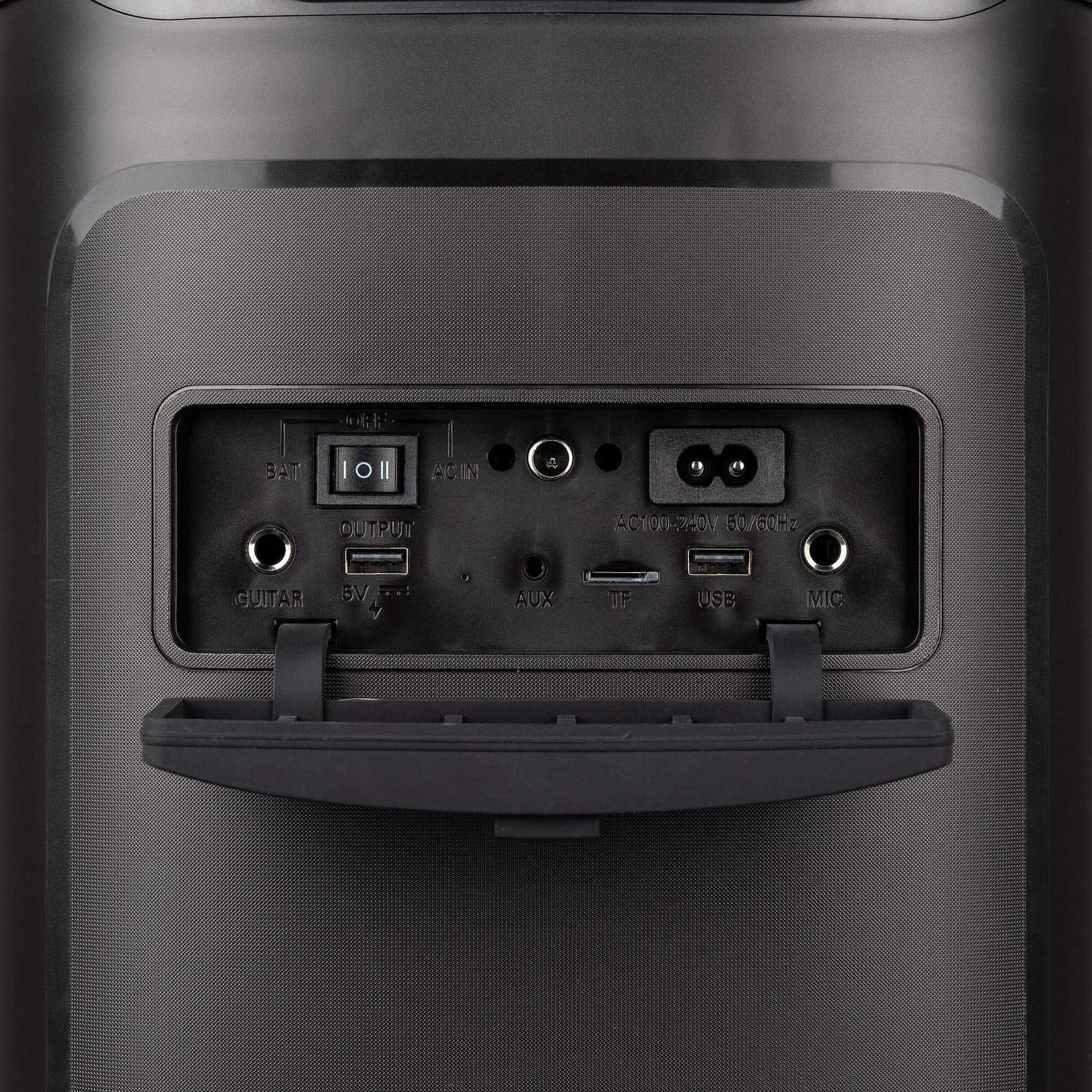 Panel trasero de altavoz negro con varios puertos: guitarra, aux, USB, micrófono y entrada de alimentación.