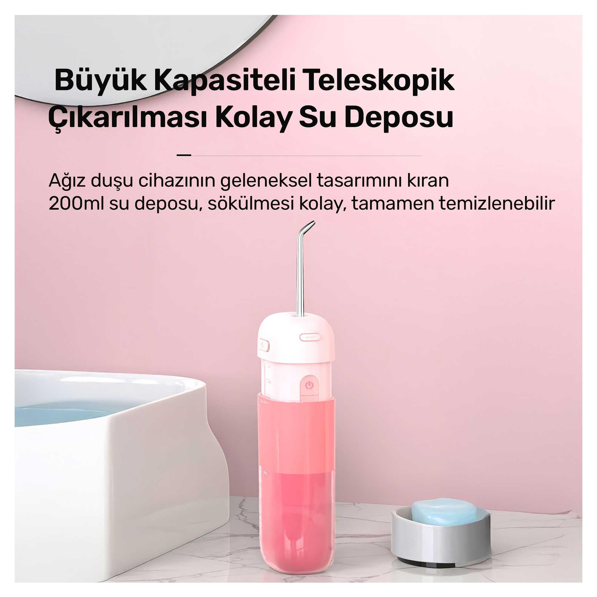 Pembe ve beyaz bir ağız duşu. Bir su haznesi vardır. Ayrıca beyaz bir havuz ve bir sabunluk da görülebilir.