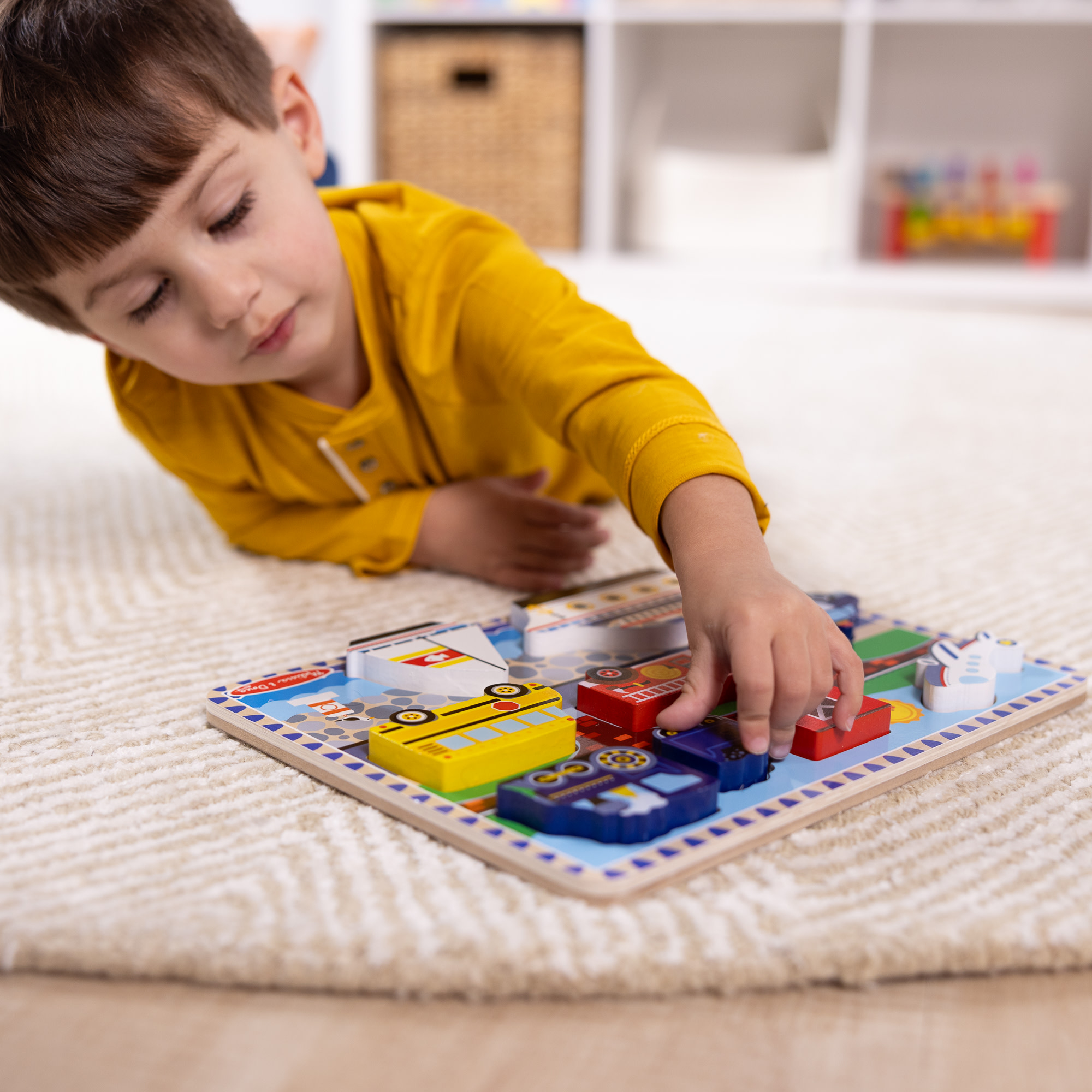 Ein Kind spielt mit einem Holzpuzzle. Das Puzzle zeigt Transportmittel, und das Kind berührt ein Teil.