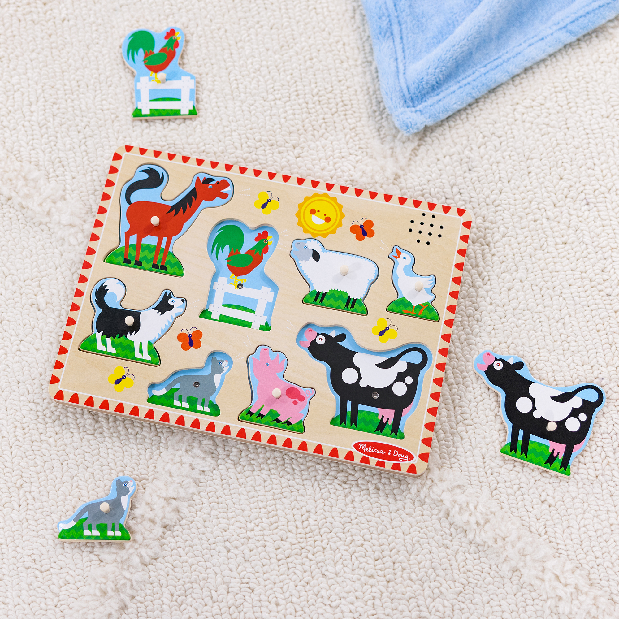 Bauernhof-Holzpuzzle mit Tierfiguren auf einem weißen Teppich. Enthält einen Hahn, ein Pferd, eine Kuh, ein Schaf und andere Tiere.