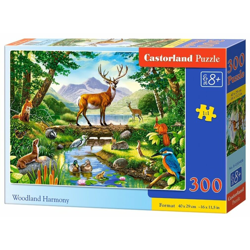 Puzzledose zeigt eine Waldszene mit Hirschen, Enten und verschiedenen Tieren in der Nähe eines Sees. Bäume und Berge im Hintergrund.