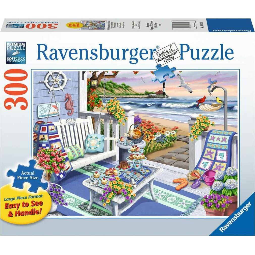 Una scatola di puzzle Ravensburger mostra una scena sulla spiaggia: un portico con cibo, fiori e un'altalena, con vista sull'oceano e un faro.