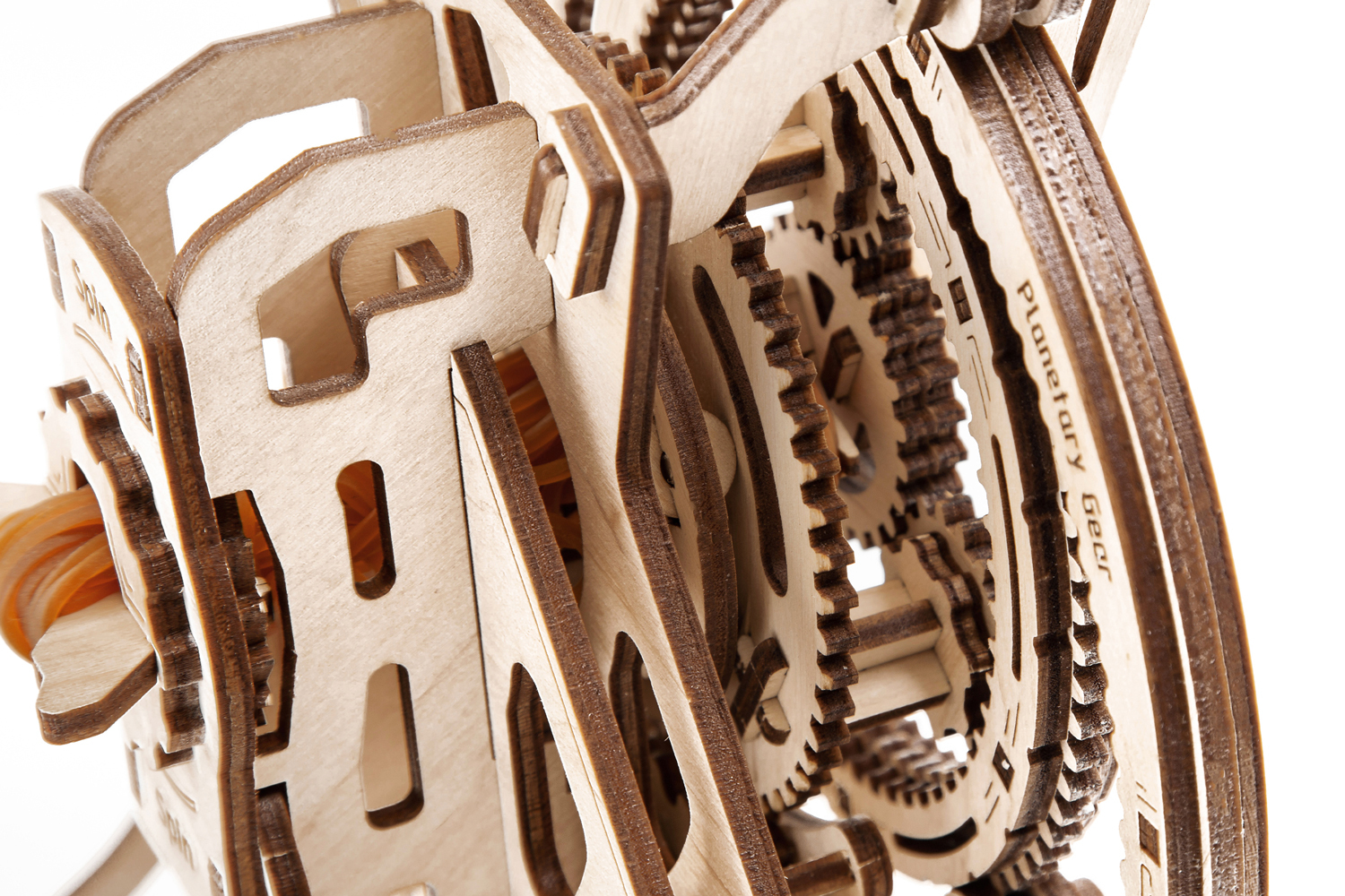 Mécanisme d'engrenage en bois avec des pièces imbriquées détaillées. Les mots 'Planetary Gear' sont visibles. Des élastiques sont également présents.
