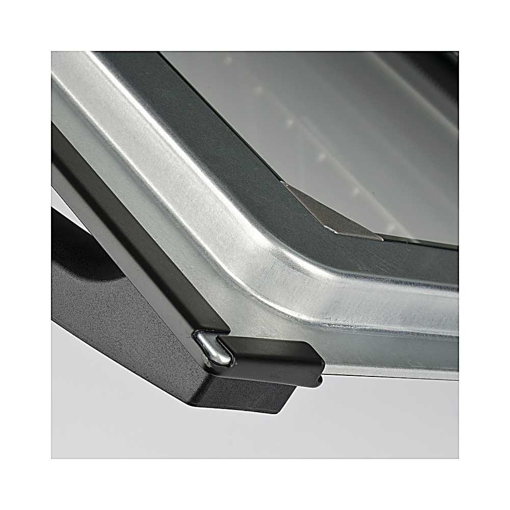 Primer plano de una estructura metálica con una pieza de esquina negra. El metal es brillante, con superficie gris. La esquina es negra.