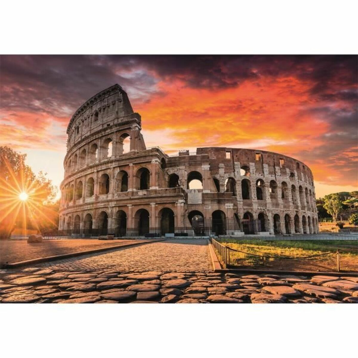 El Coliseo al atardecer. El cielo es ardiente. El antiguo anfiteatro romano está en primer plano, con ventanas arqueadas y fachada de piedra.