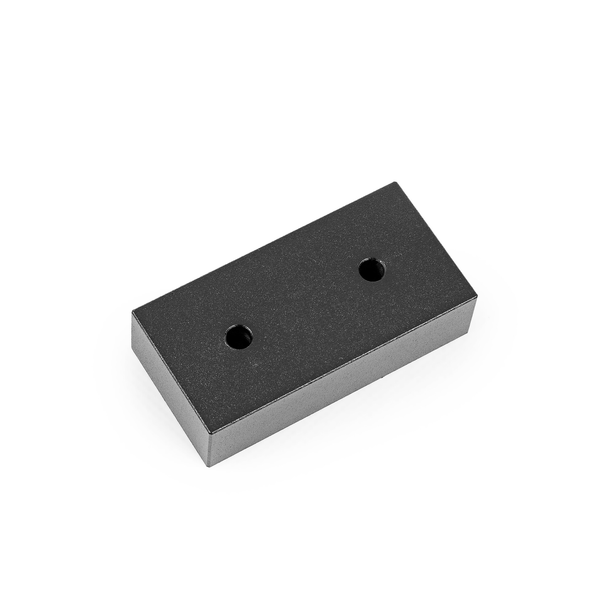 Ein rechteckiger schwarzer Metallblock mit zwei Löchern auf weißem Hintergrund.