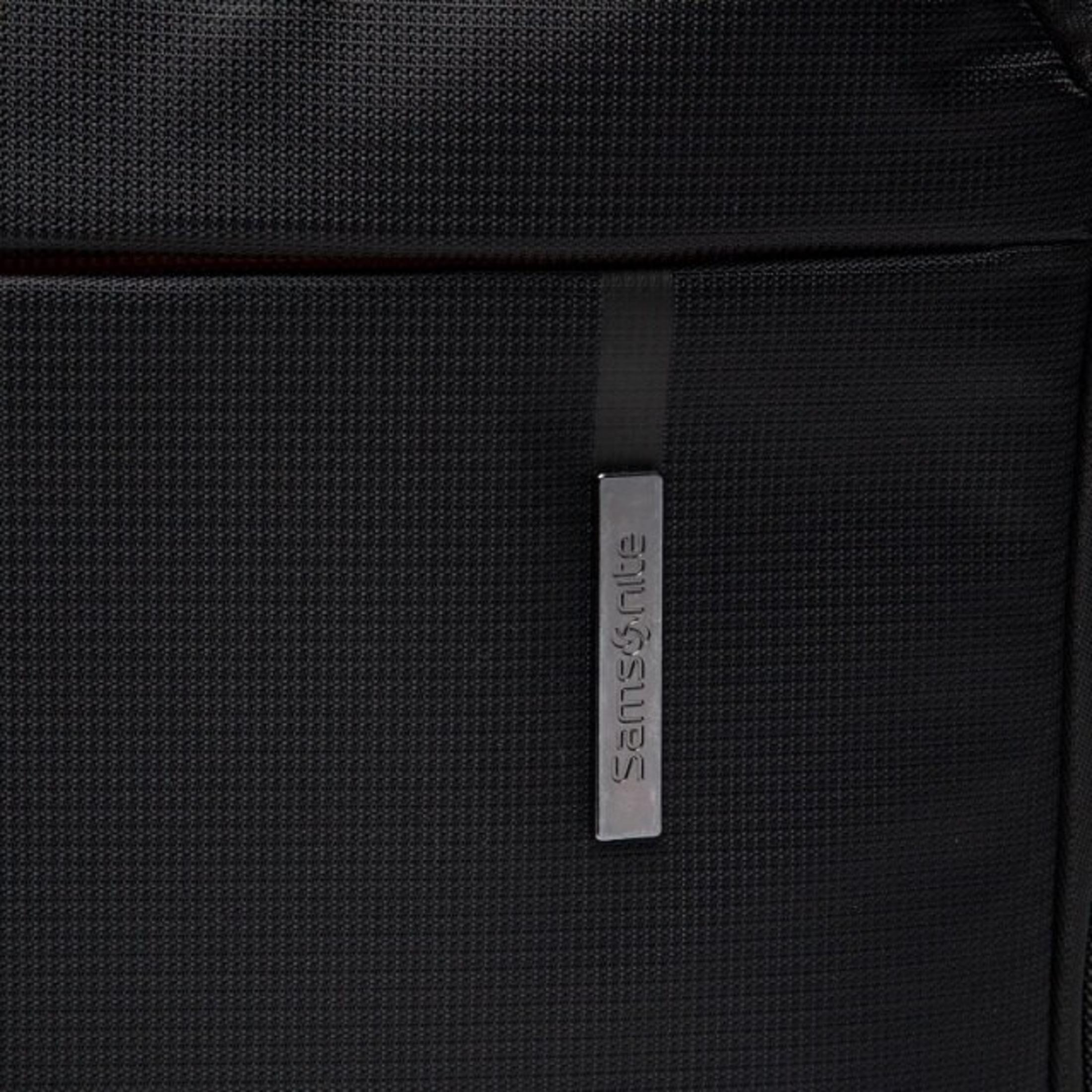 Primo piano di una borsa Samsonite nera. Visibile un'etichetta in metallo argentato con il nome del marchio.