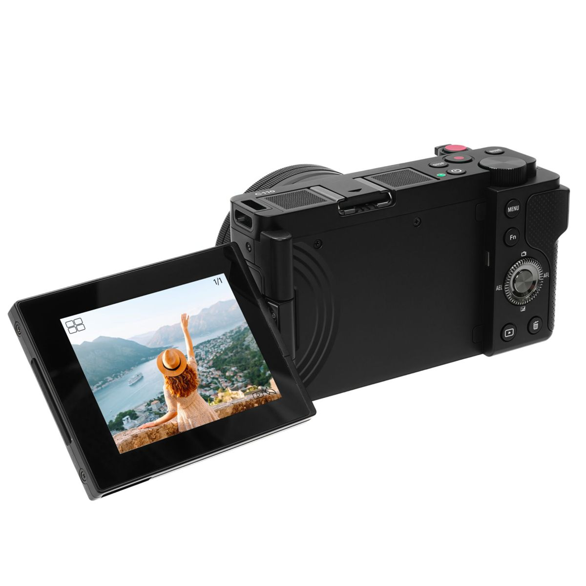Een zwarte camera met een uitgeklapt scherm waarop een vrouw met een hoed te zien is, die uitkijkt over een baai. De camera staat op een wit oppervlak.