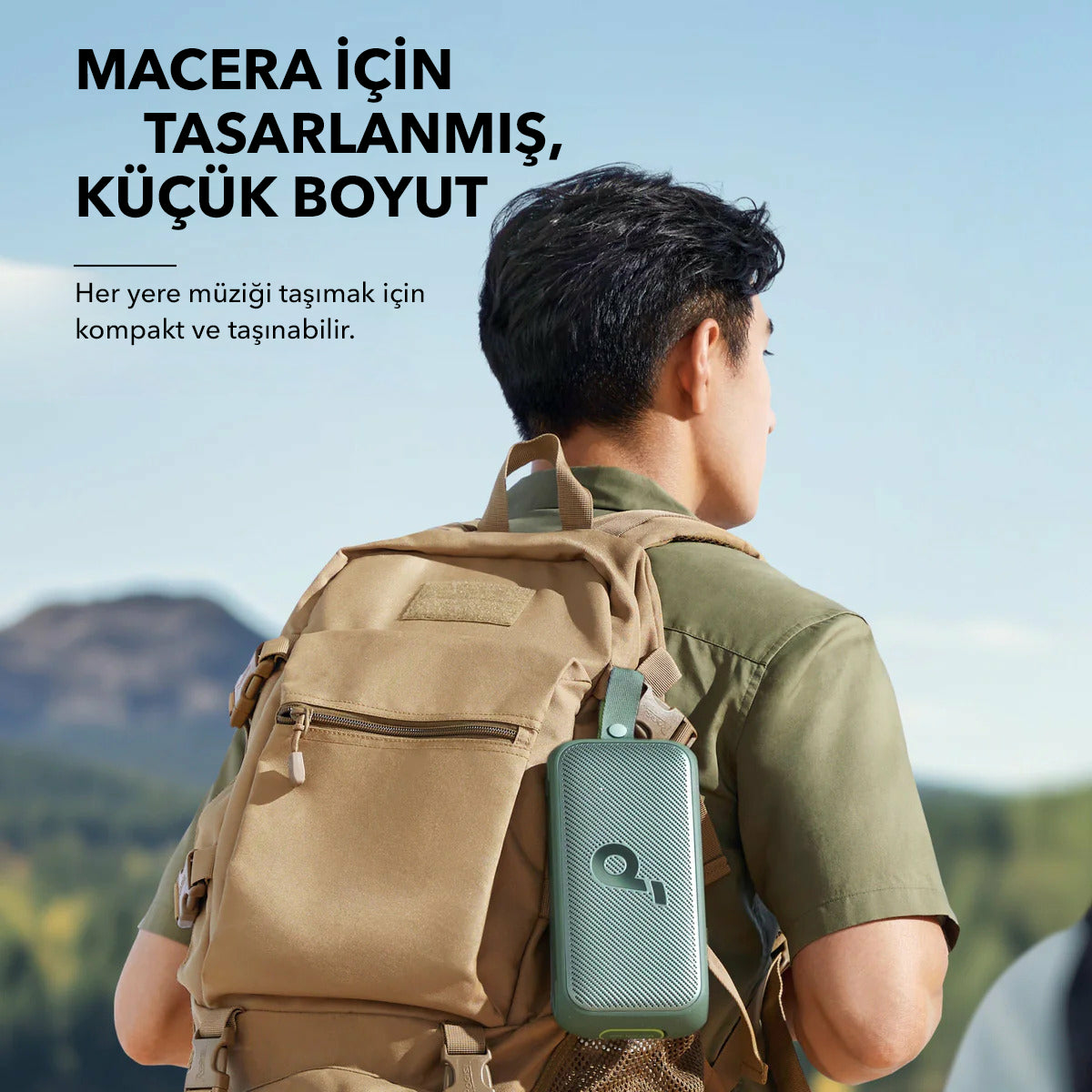 Mężczyzna z plecakiem i głośnikiem. Tekst: Zaprojektowany do przygód, mały rozmiar. Tekst po turecku.