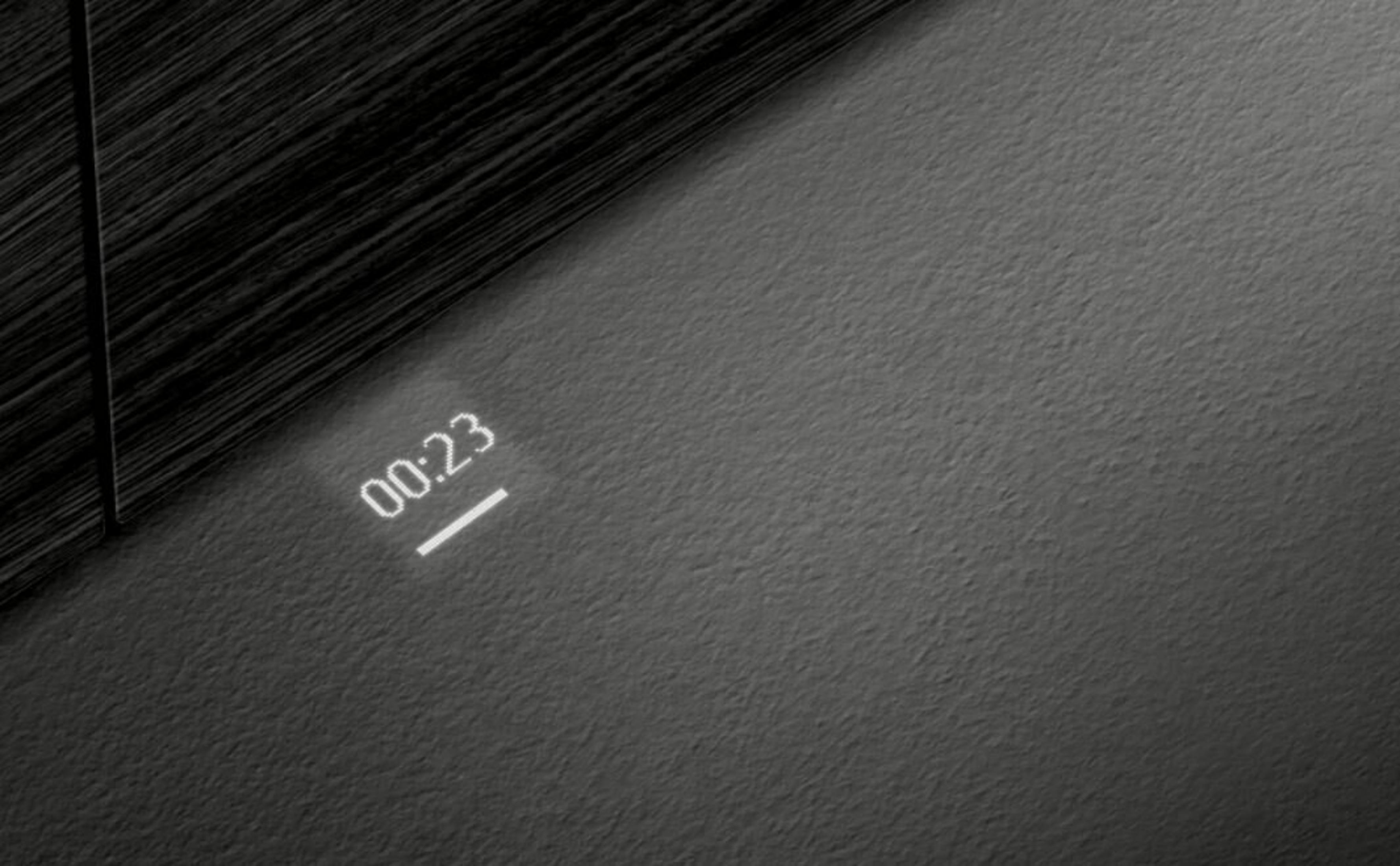 L'image montre un coin avec une minuterie affichant 00:23. Le fond est gris et en bois sombre.