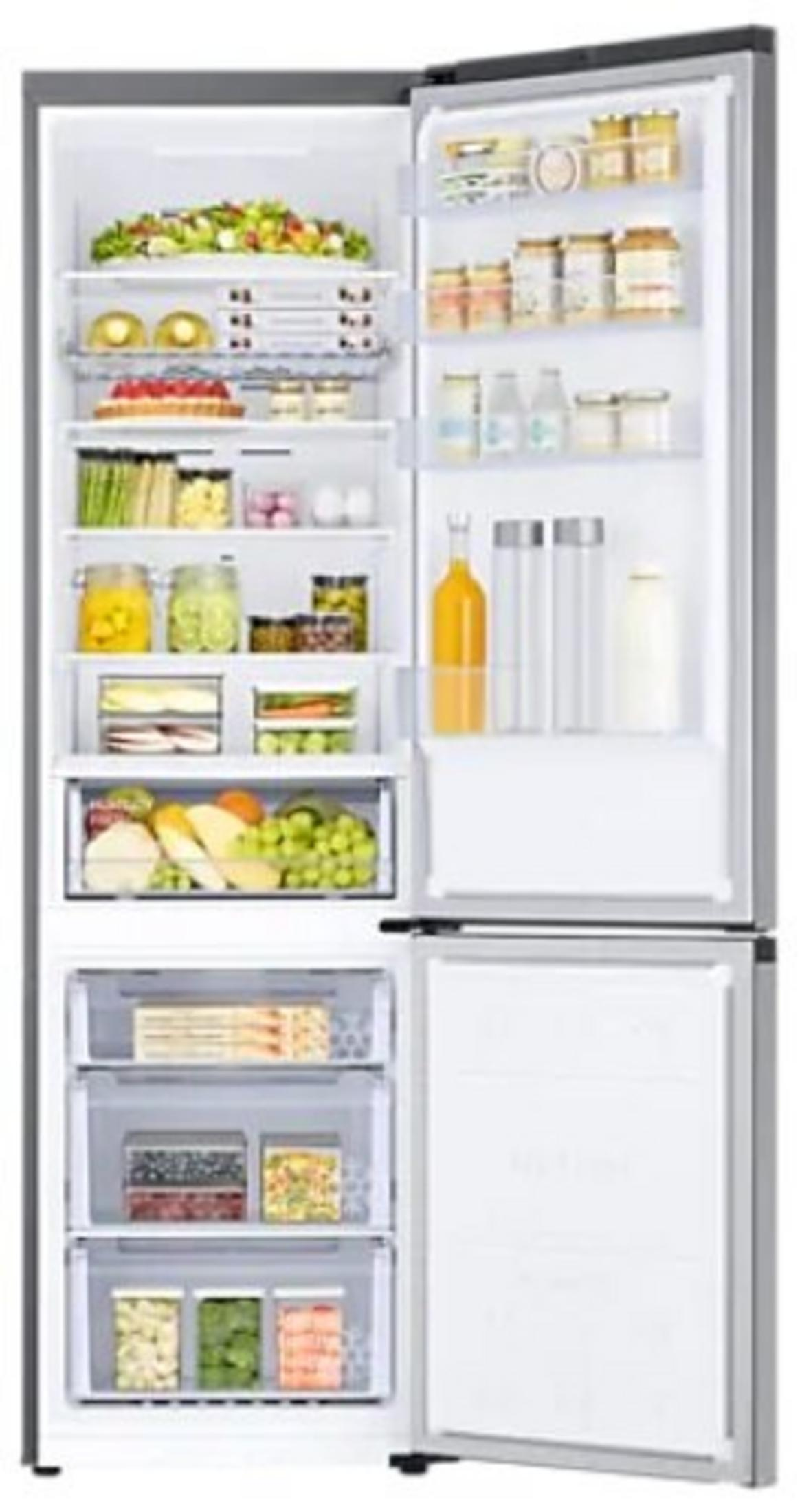 Refrigerador abierto lleno de comida: frutas, verduras, frascos y botellas. Los cajones del congelador también están llenos.