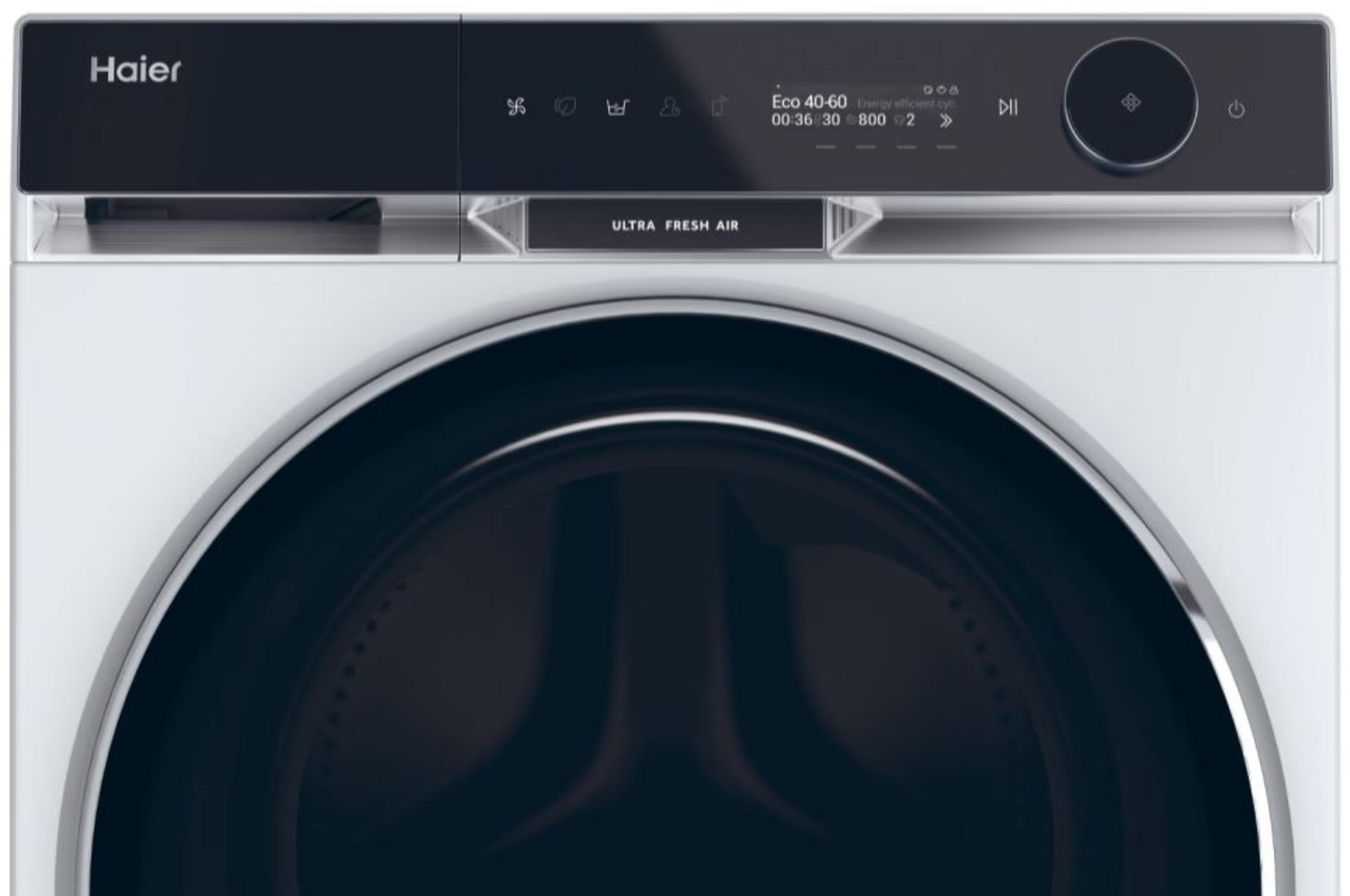 Una lavadora Haier blanca. Tiene un panel de control negro con pantalla y una puerta grande.