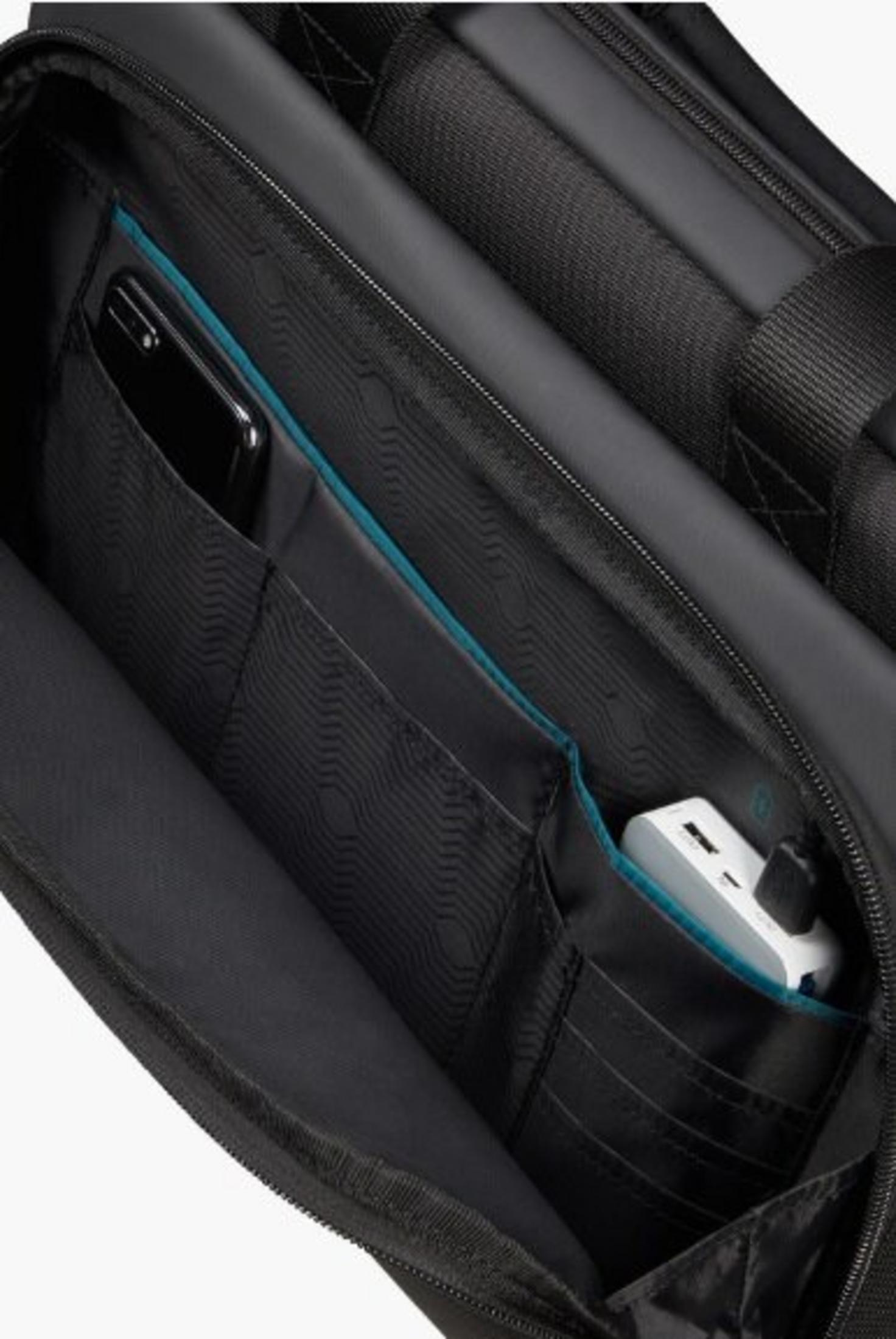 All'interno di una borsa nera: un telefono e un adattatore di alimentazione sono visibili in tasche con finiture blu.