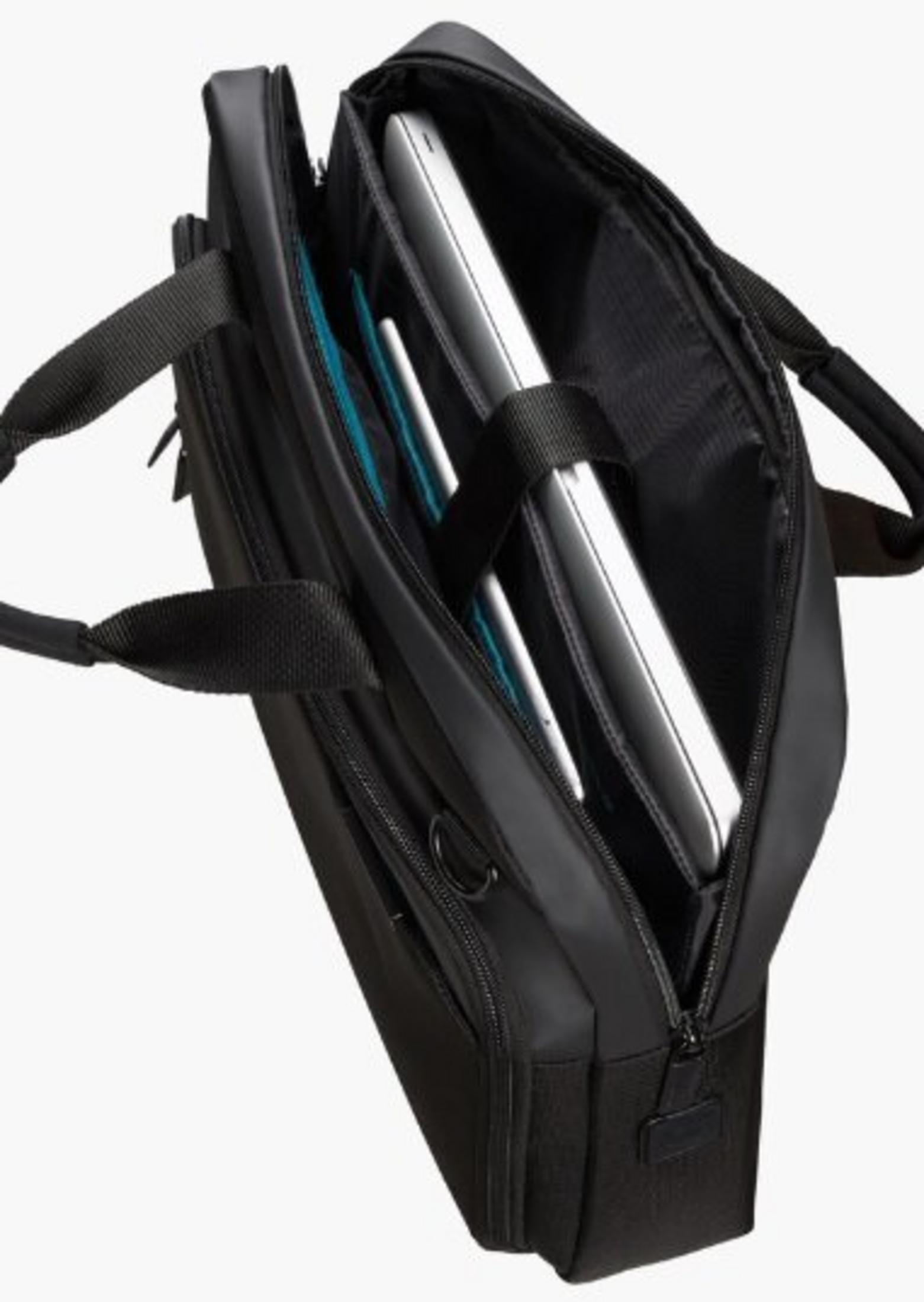 Valigetta nera, parzialmente aperta. Un laptop e un tablet sono visibili. Dettagli manici e cerniere.