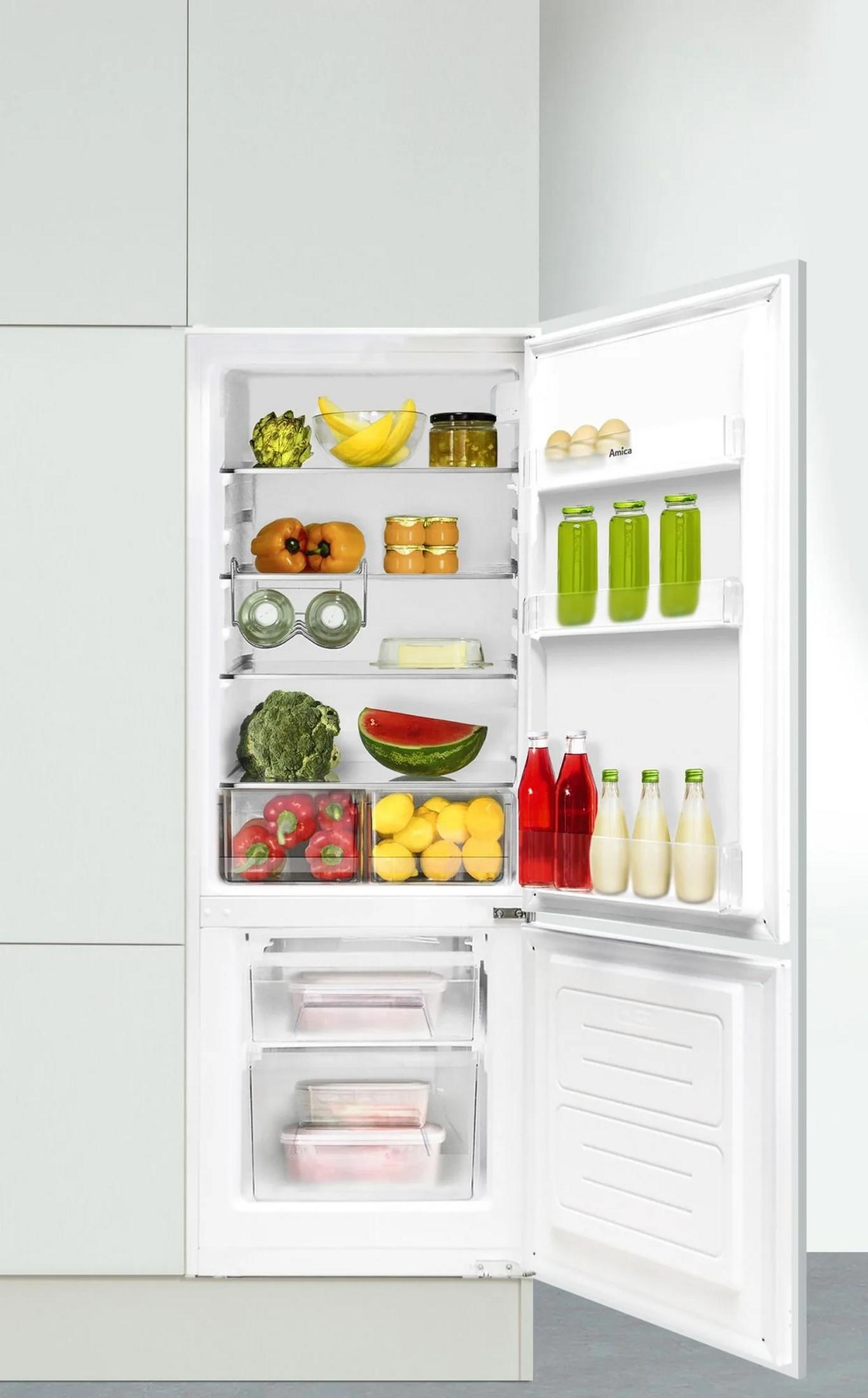 Una porta del frigorifero bianca aperta, che mostra ripiani pieni di frutta, verdura, bevande e contenitori di cibo.