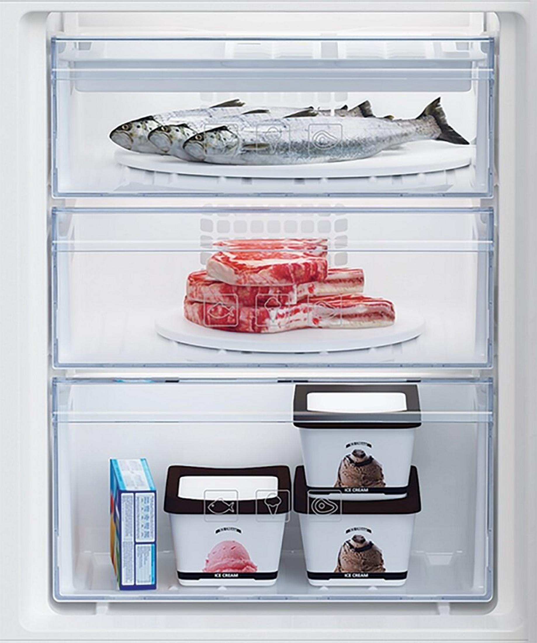Interior de nevera con pescado, carne y helado en bandejas. Una caja de alimentos congelados en la balda inferior.