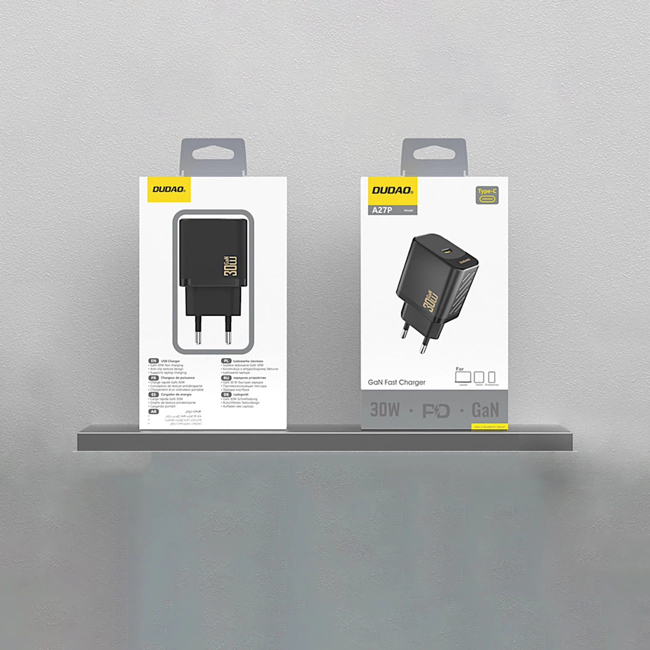 Dwa pudełka szybkich ładowarek DUDOA GaN na półce. Pudełka pokazują ładowarki i ich specyfikacje, takie jak 30W i Type-C.