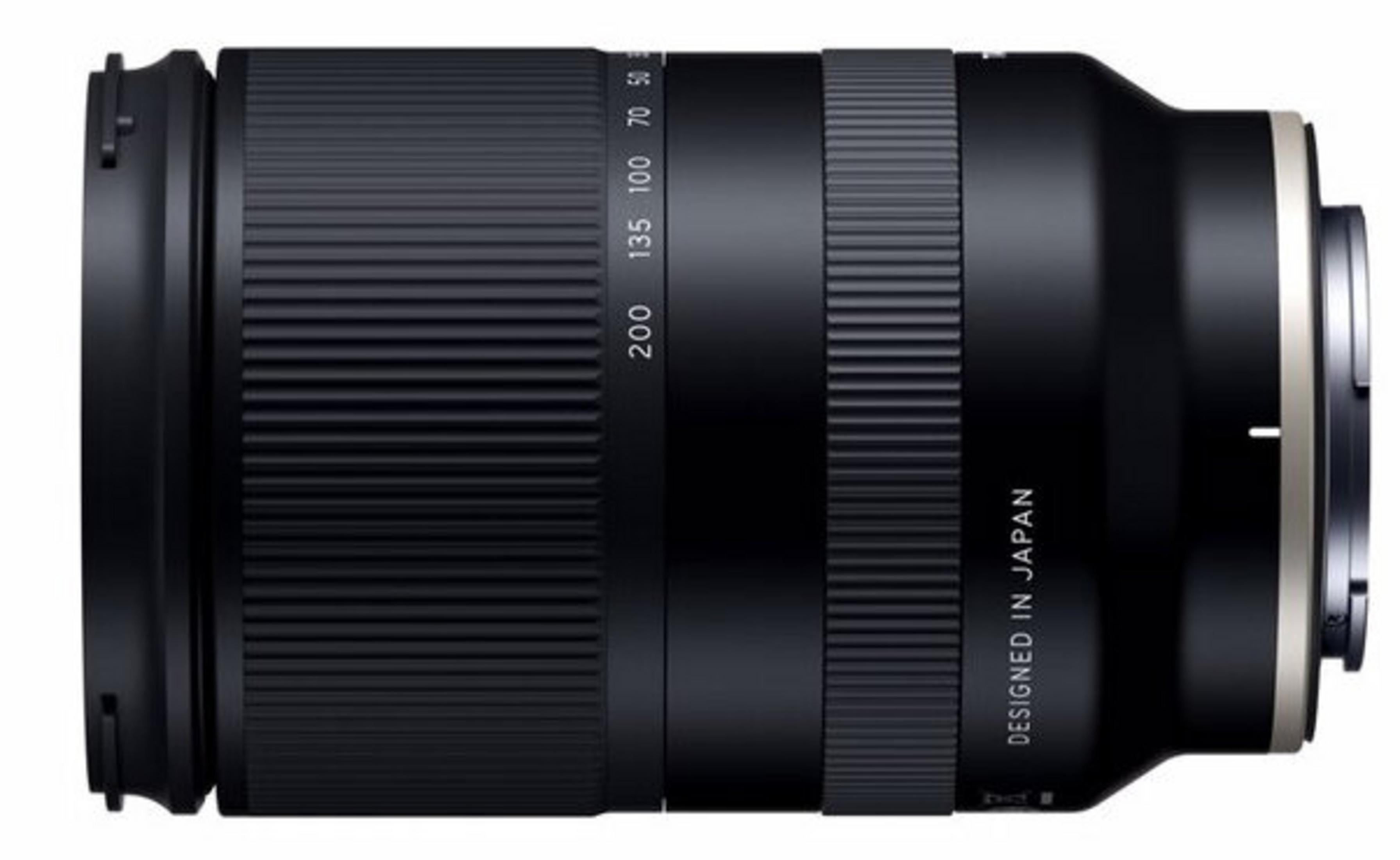 Czarny obiektyw aparatu z oznaczeniami odległości ogniskowej. Napisano 'Designed in Japan'. Obiektyw ma żebrowane sekcje.