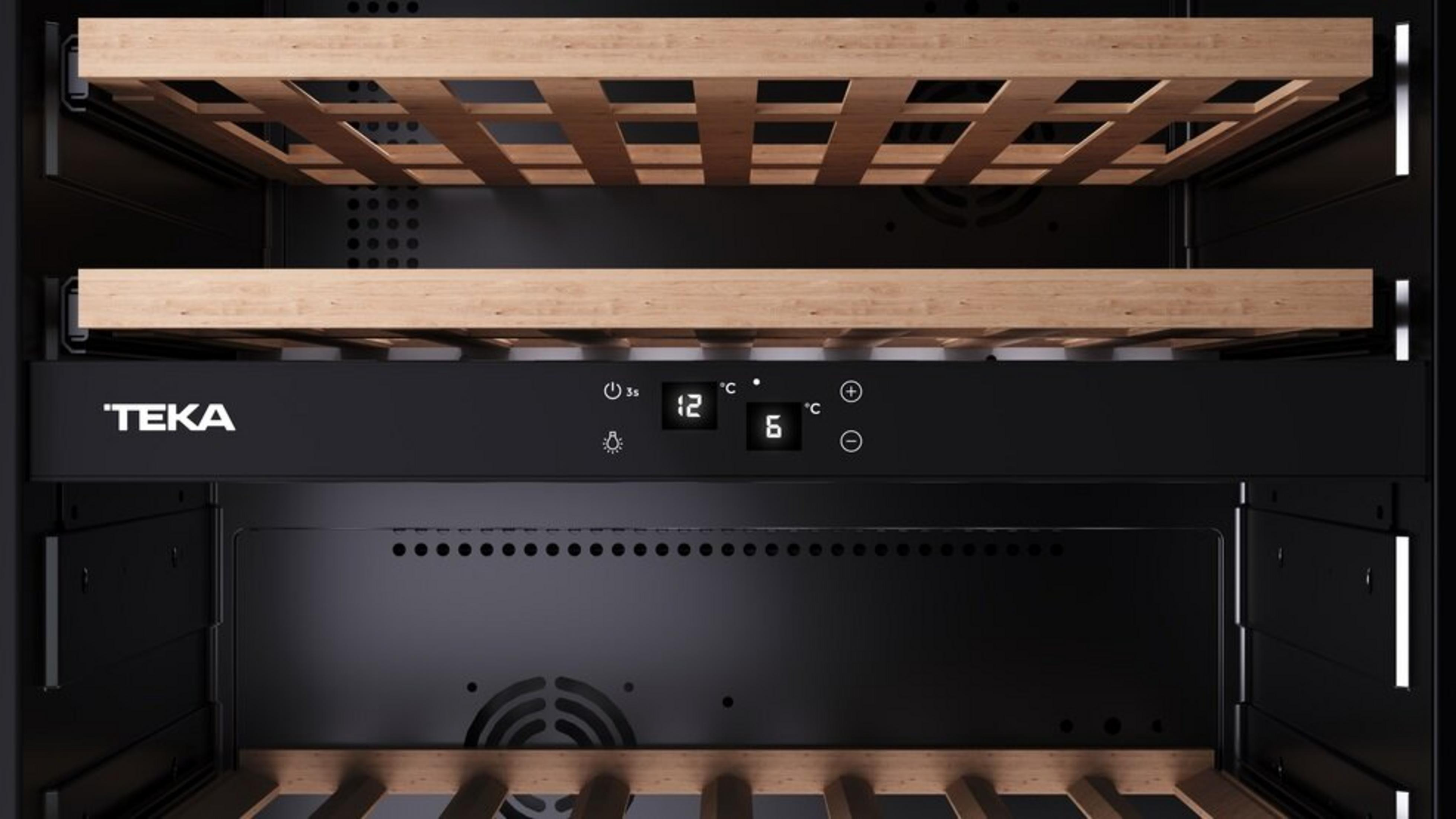 Wnętrze chłodziarki do wina. Drewniane półki, cyfrowy wyświetlacz temperatury i logo 'TEKA'. Dominują czarne i drewniane odcienie.