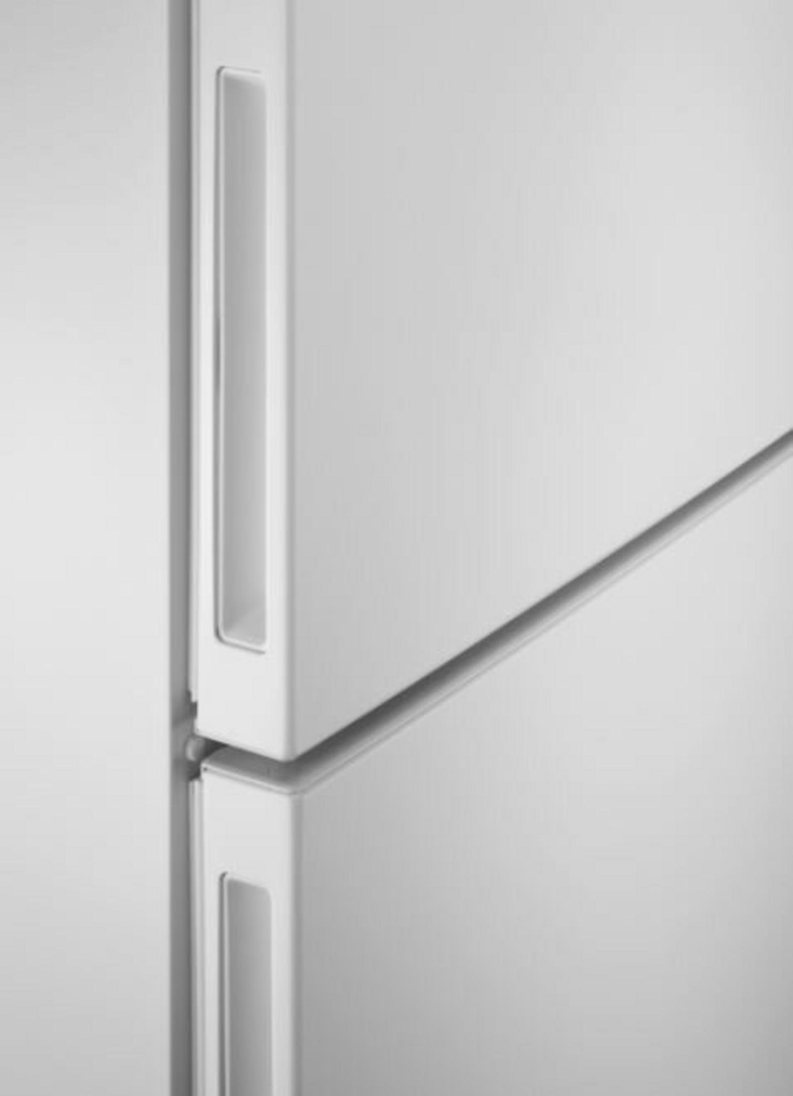 Primo piano di un frigorifero bianco. L'immagine mostra la porta con la maniglia e le sezioni superiore e inferiore.