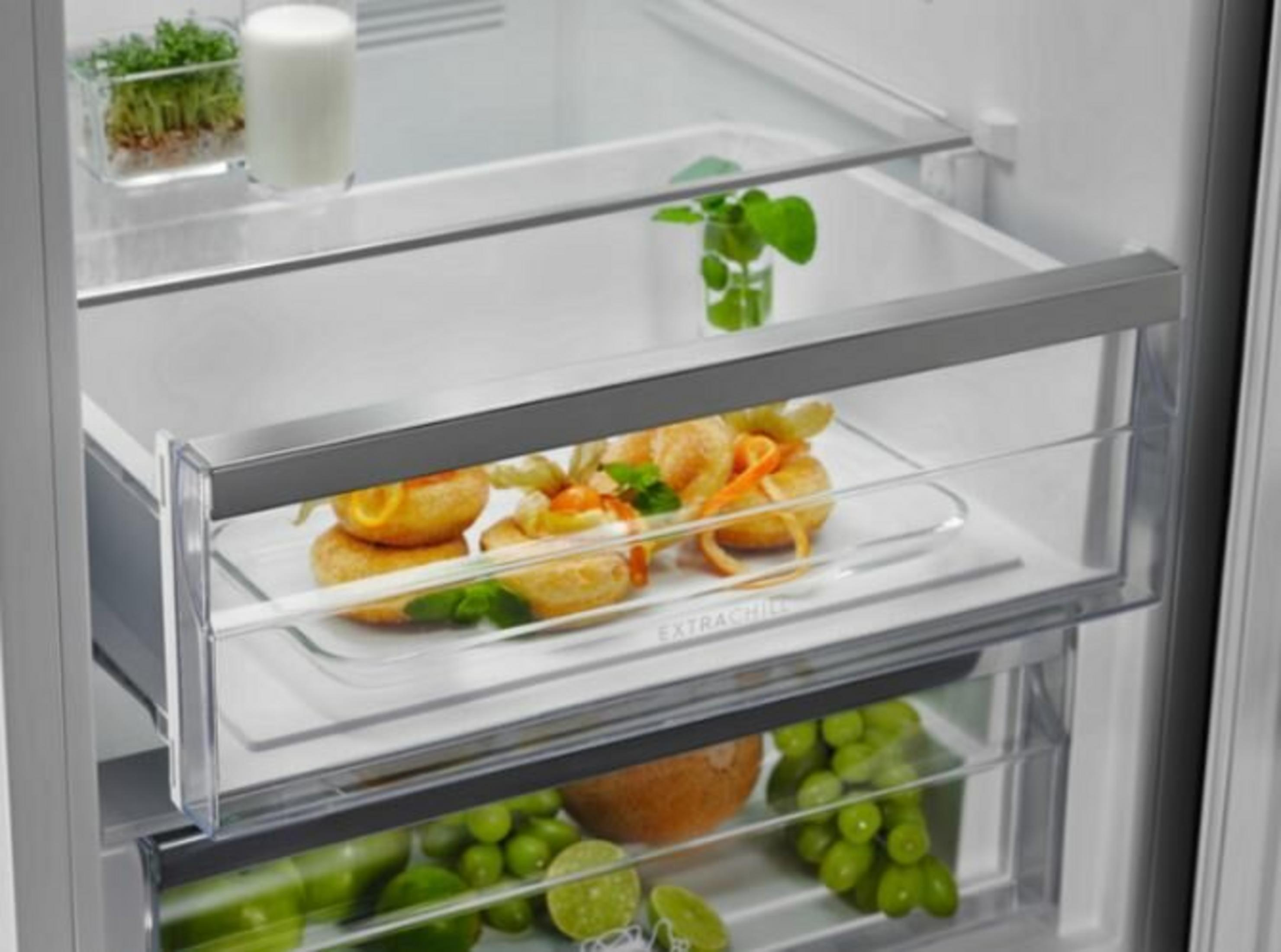 All'interno di un frigorifero ci sono alimenti come pane, uva e altre verdure.