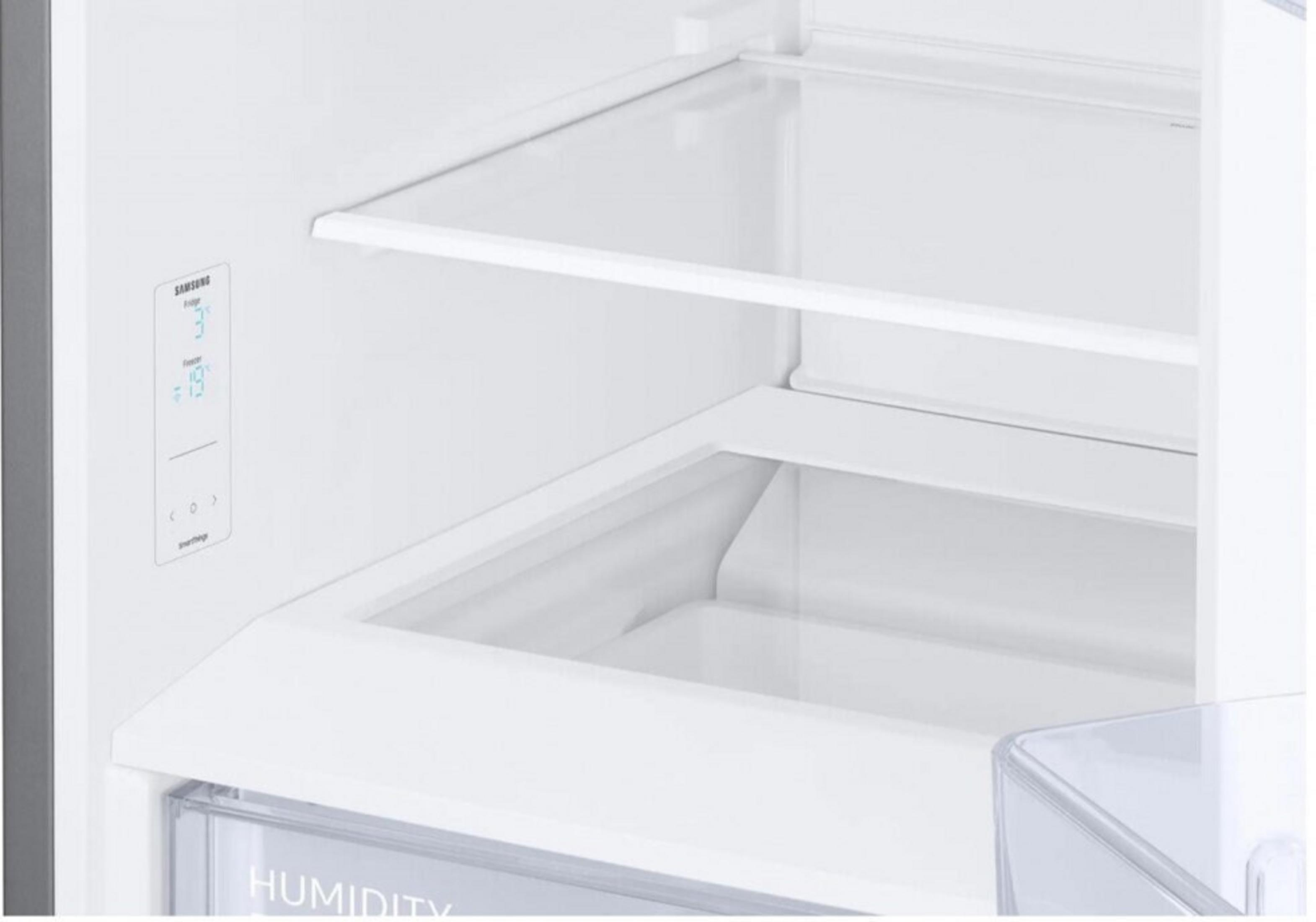 All'interno di un frigorifero bianco. Ci sono ripiani e un cassetto per l'umidità. Il frigorifero mostra le letture della temperatura.