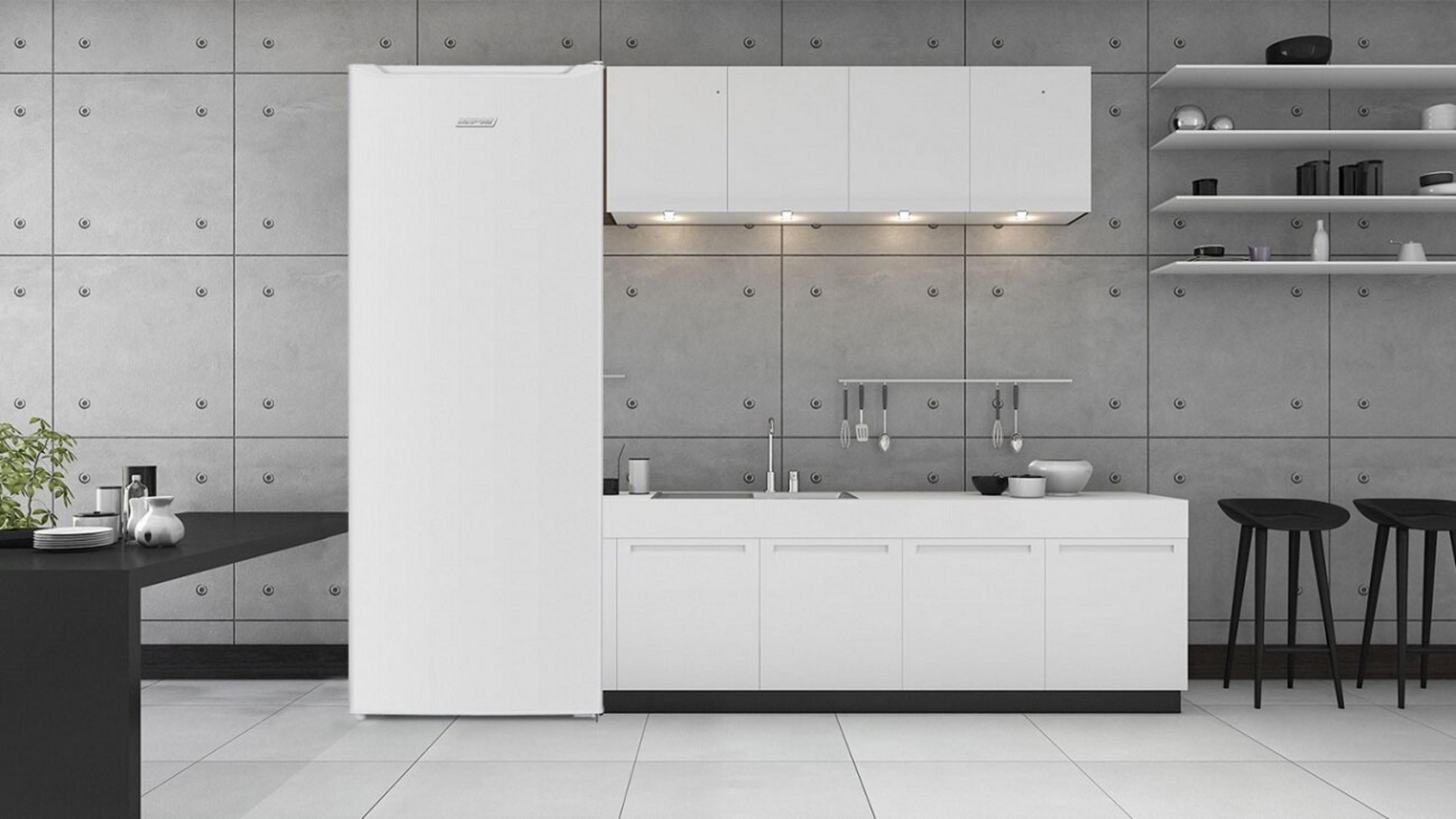 Nowoczesna kuchnia z białymi szafkami, lodówką i czarnym blatem. Szara betonowa ściana. Dwa czarne stołki przy ladzie.