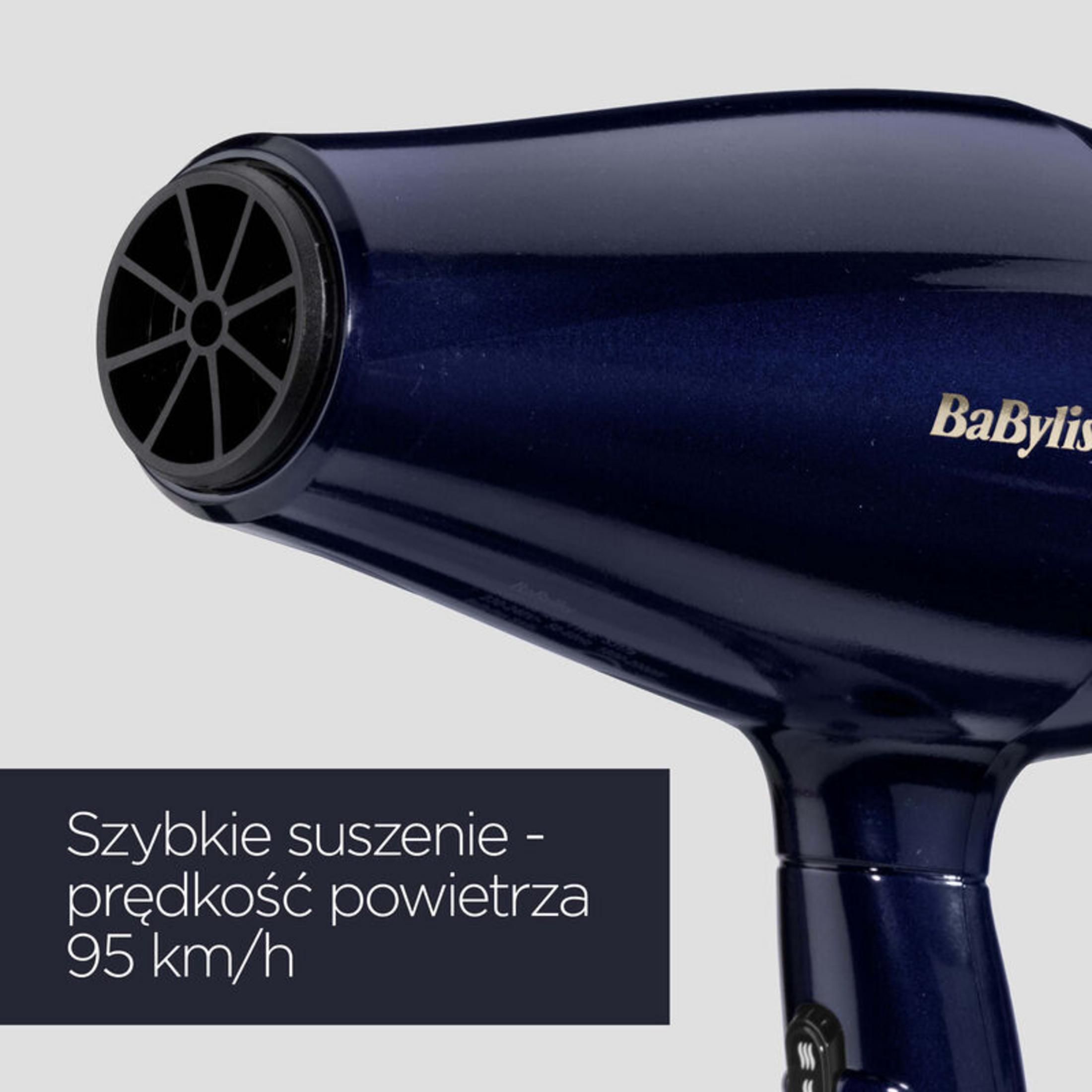 Un asciugacapelli Babyliss blu scuro. La parte anteriore ha una griglia nera. Testo: Asciugatura rapida - velocità dell'aria 95 km/h.