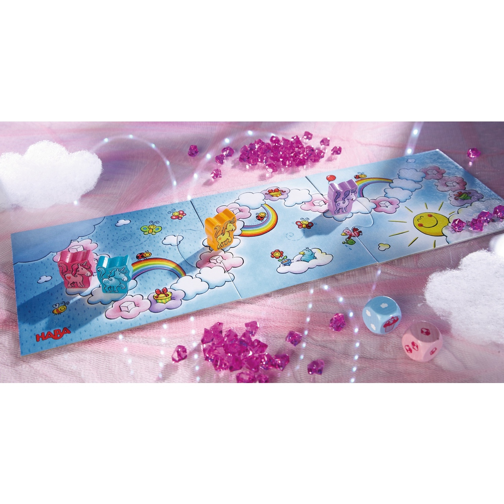 Ein Kinderspiel mit Einhörnern, Regenbögen, Würfeln und rosa kristallartigen Dekorationen. Das Spiel befindet sich auf einem Brett im Himmel-Thema.