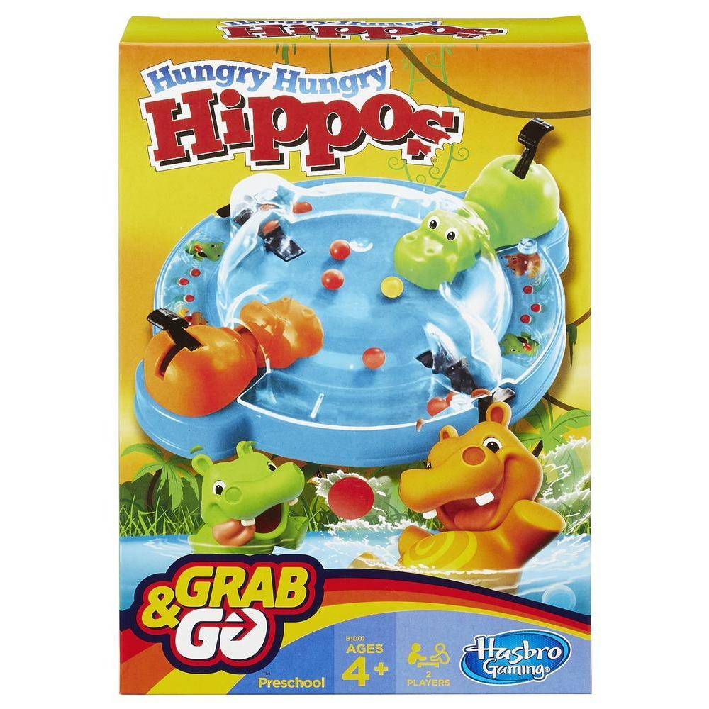 Hungry Hungry Hippos Spielbox. Zeigt Nilpferdfiguren, ein Spielbrett und das Logo des Spiels, mit roten und orangefarbenen Kugeln.